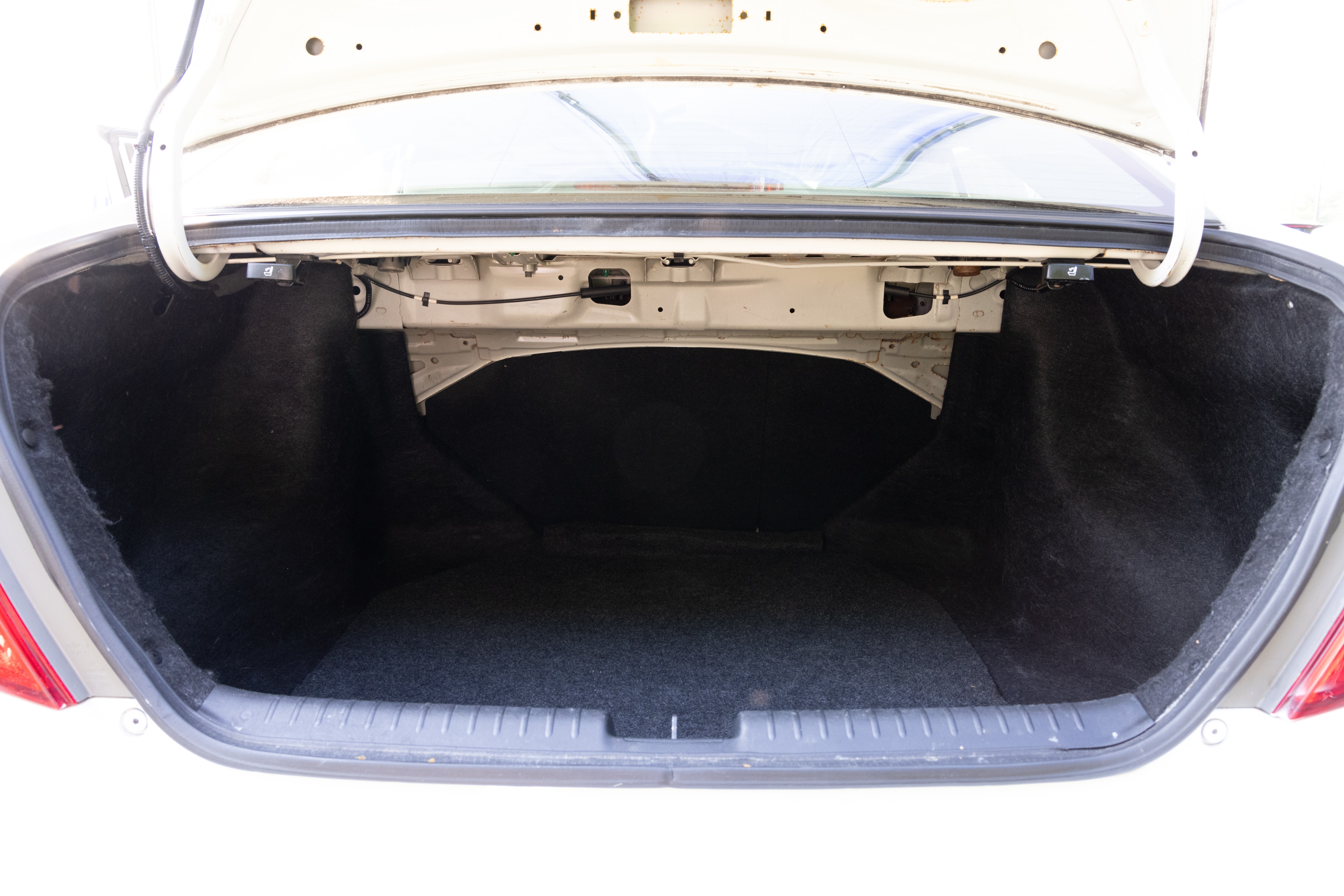 The trunk area is open giving a full view of the trunk area. A baby stroller, four grocery carriers, a yoga mat, and a set of golf clubs are placed inside.
