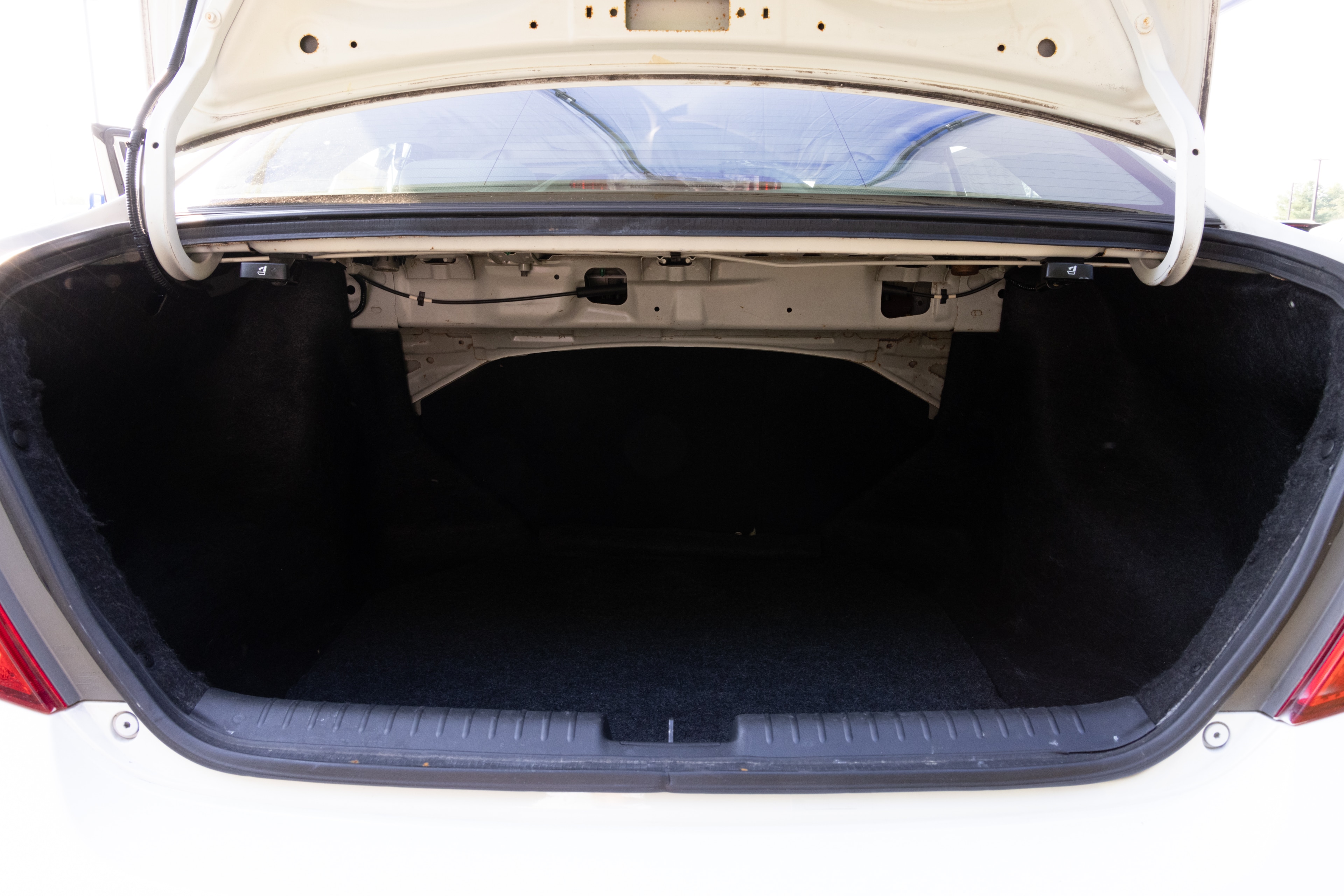 The trunk area is open giving a full view of the trunk area. Two large and two small suitcases are placed on their sides.