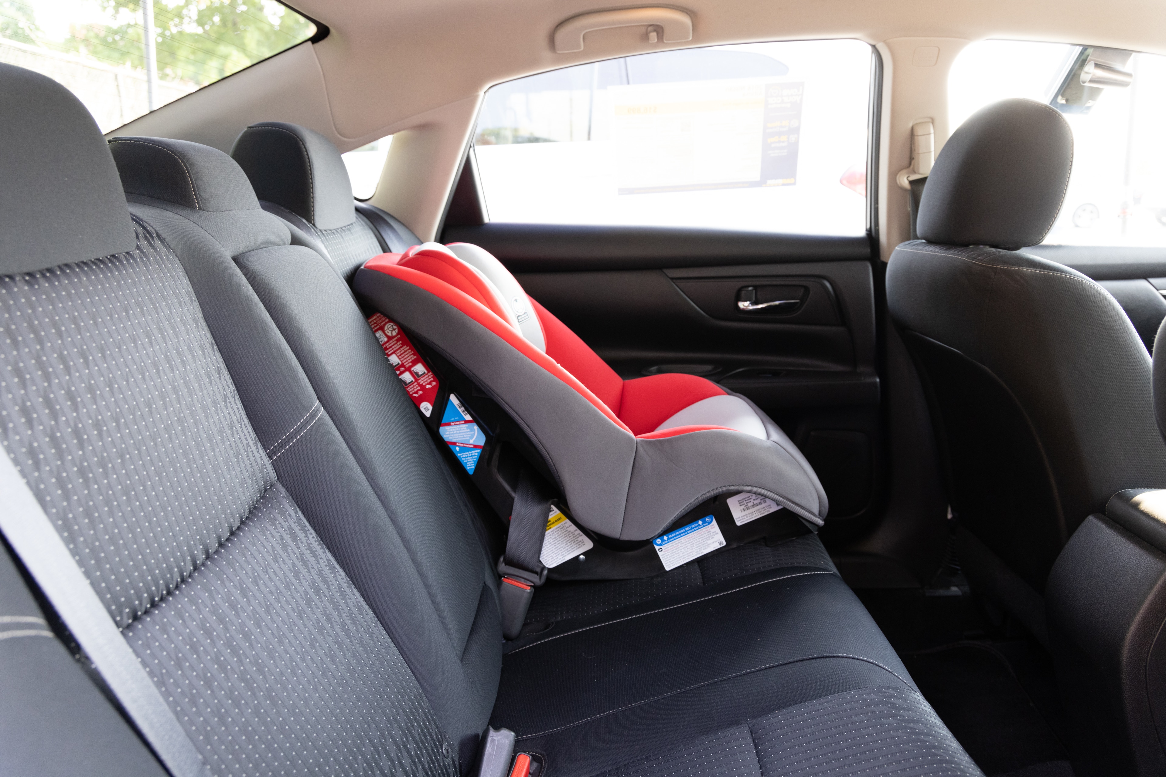 A series of second-row backseat photos is shown including one seating a baby seat and one seating a 6'1" mannequin.