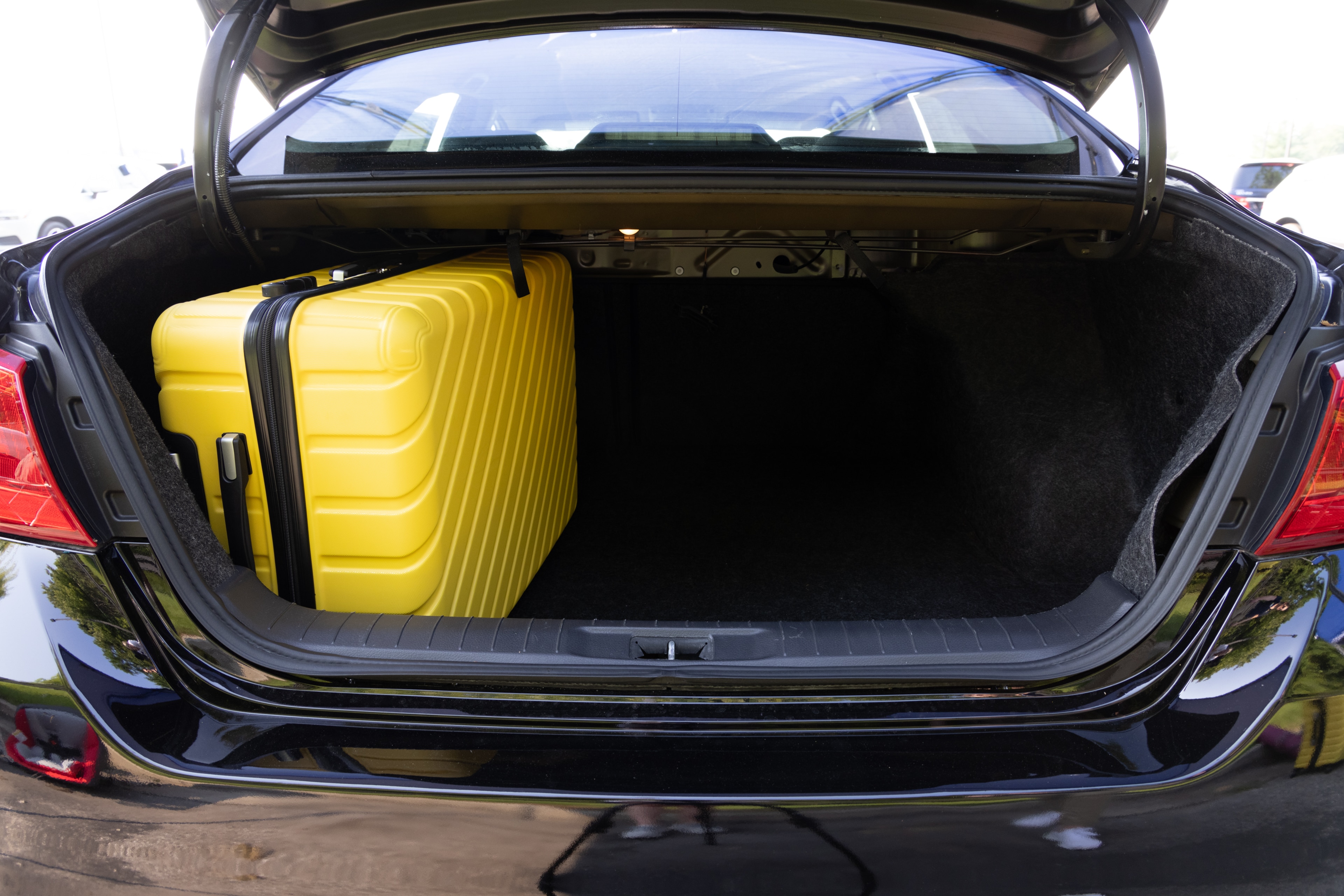 The trunk area is open giving a full view of the trunk area. Two large and two small suitcases are placed on their sides.