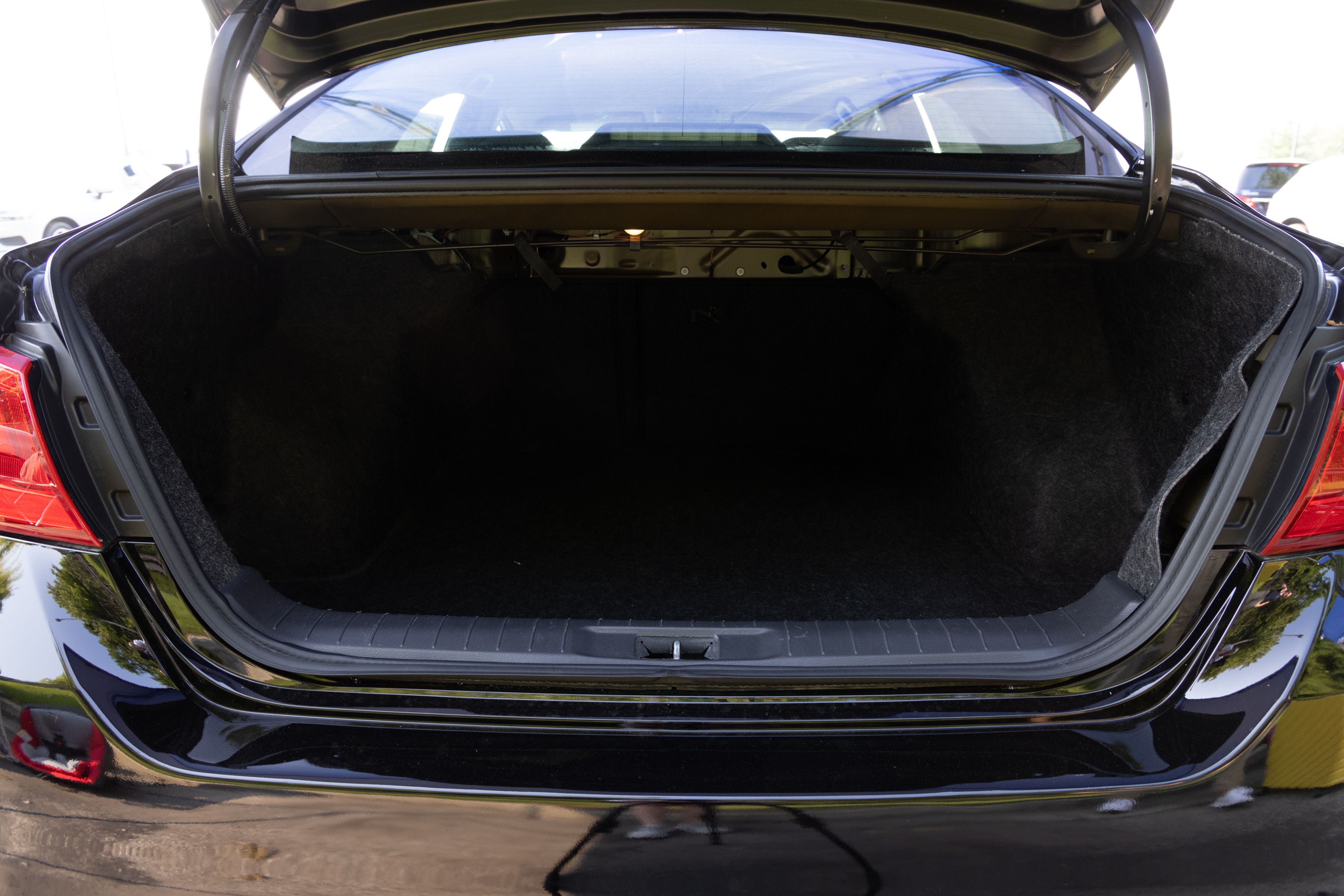 The trunk area is open giving a full view of the trunk area. Two large and two small suitcases are placed on their sides.