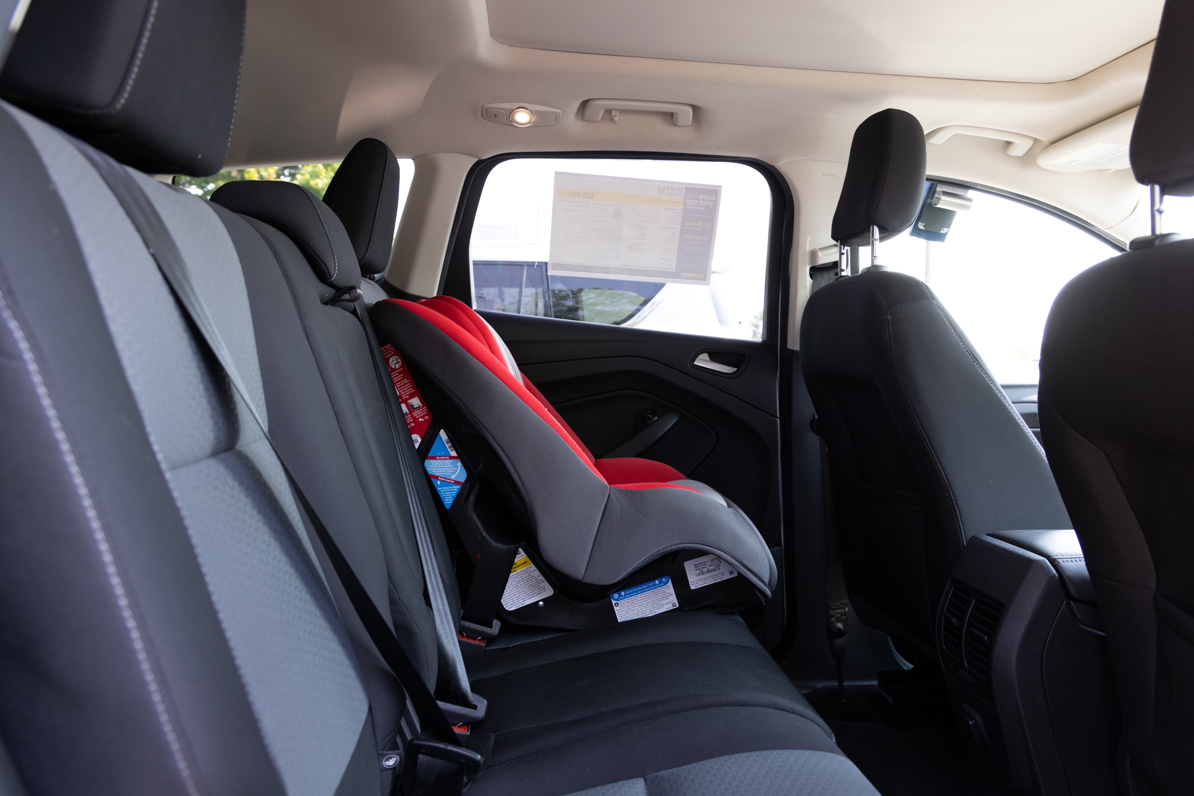 A series of second-row backseat photos is shown including one seating a baby seat and one seating a 6'1" mannequin.
