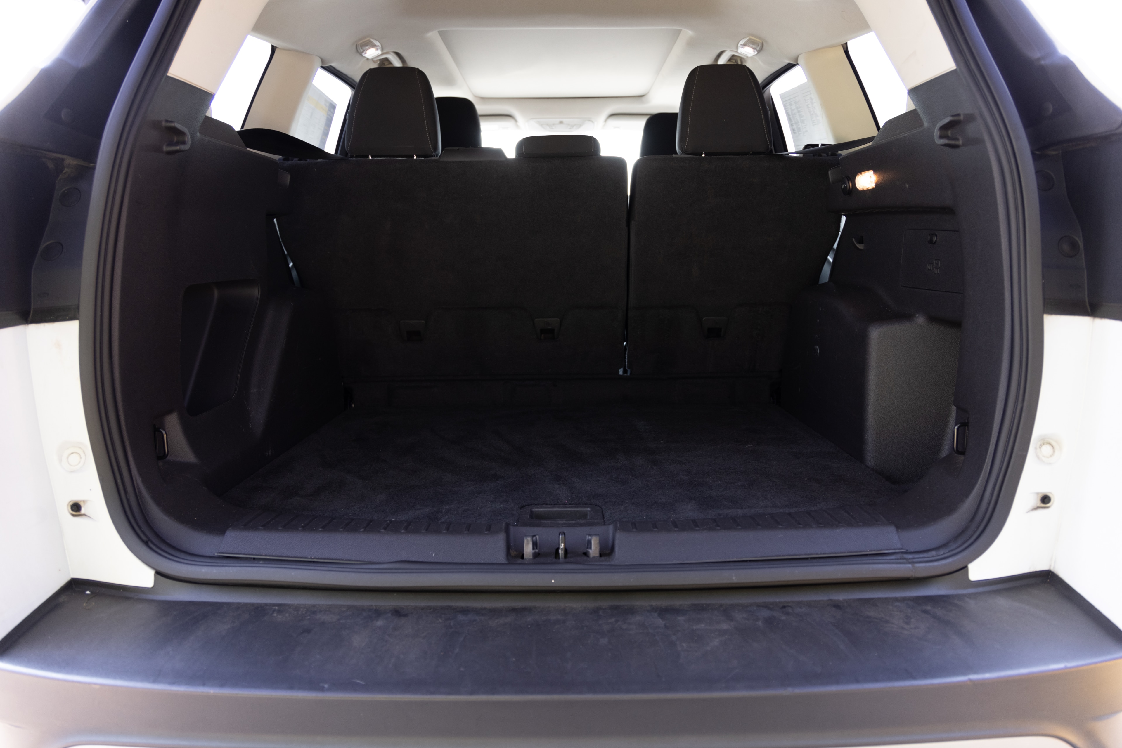 The cargo area is open giving a full view of the trunk area. Two large and two small suitcases are placed on their sides.