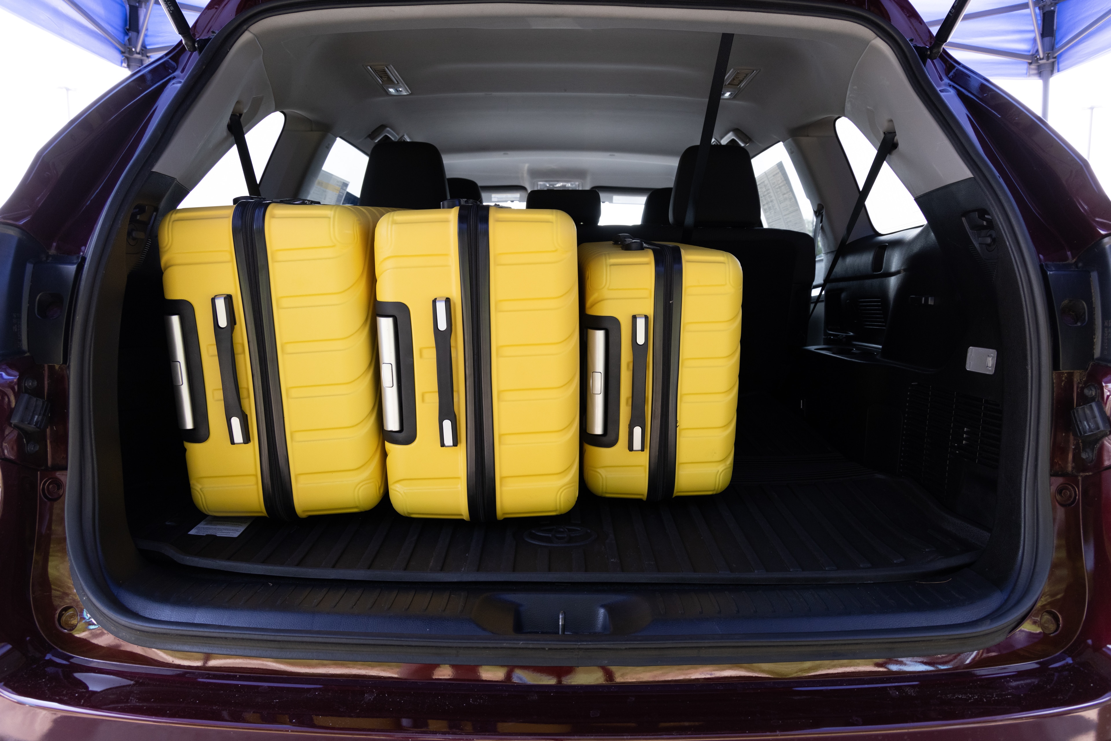 The cargo area is open giving a full view of the cargo area. Two large and two small suitcases are placed on their sides.