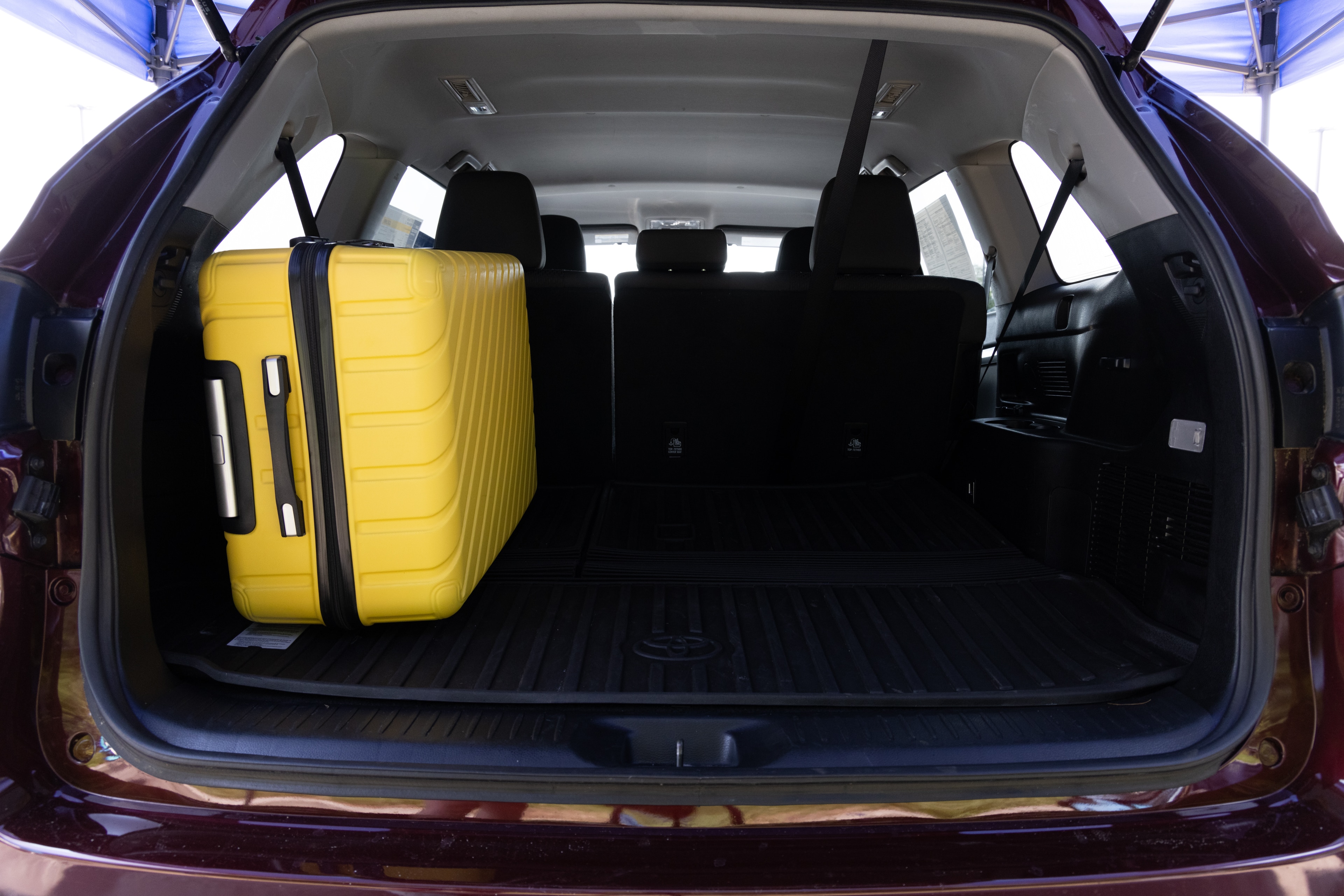 The cargo area is open giving a full view of the cargo area. Two large and two small suitcases are placed on their sides.