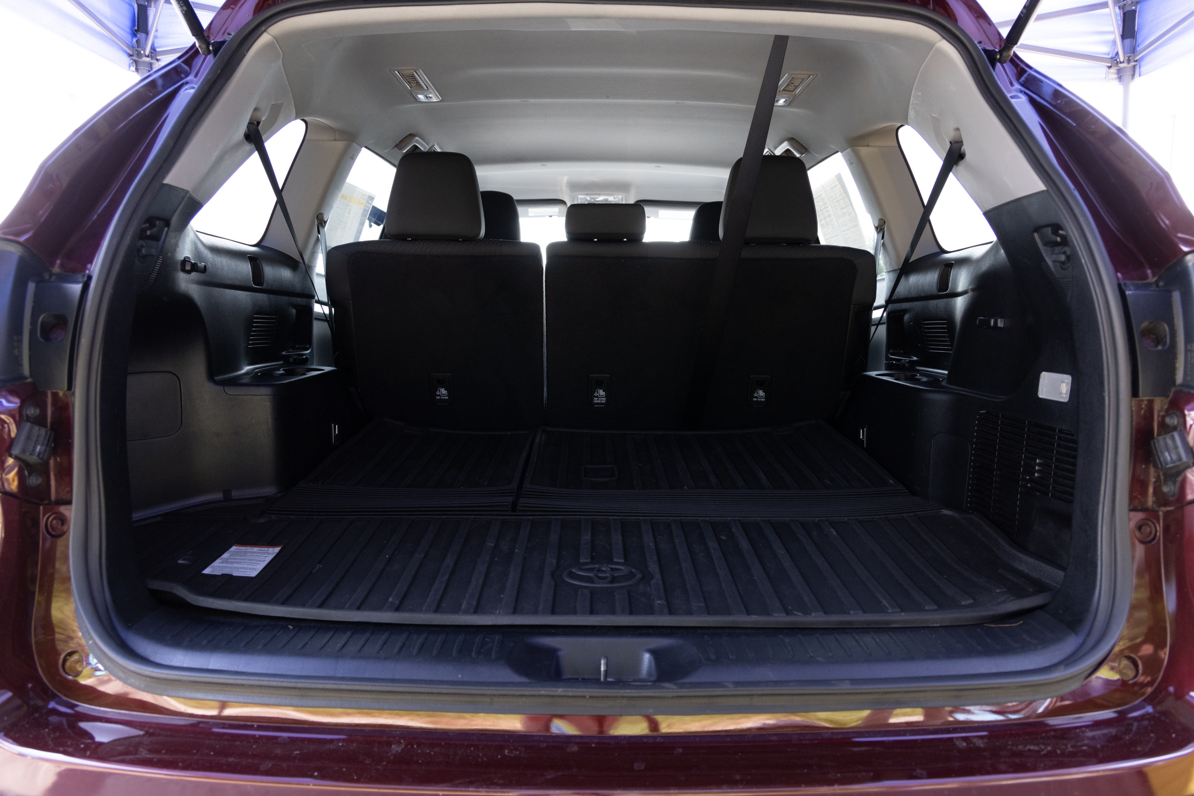 The cargo area is open giving a full view of the cargo area. Two large and two small suitcases are placed on their sides.