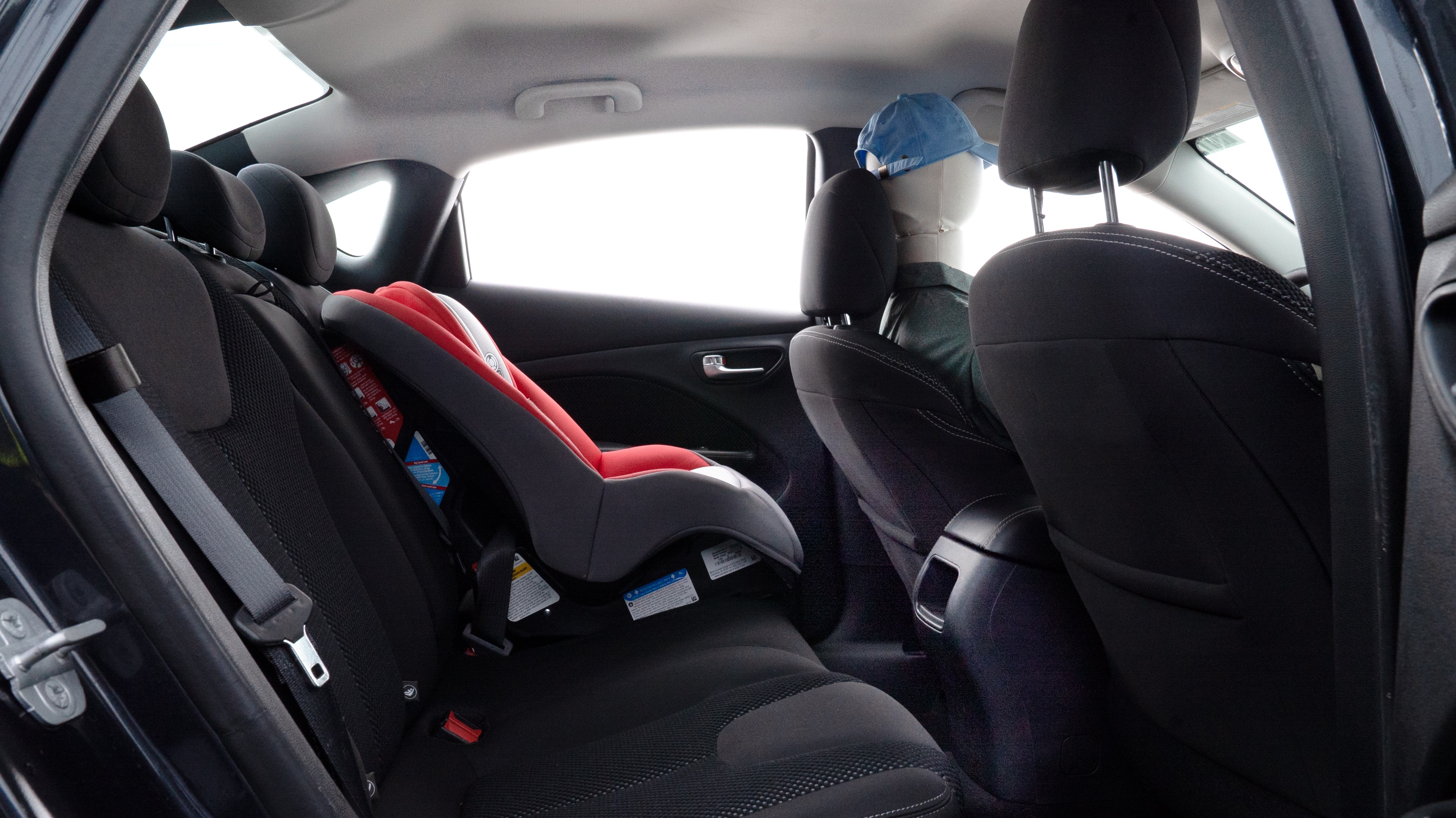 A series of second-row backseat photos is shown including one seating a baby seat and one seating a 6'1" mannequin.