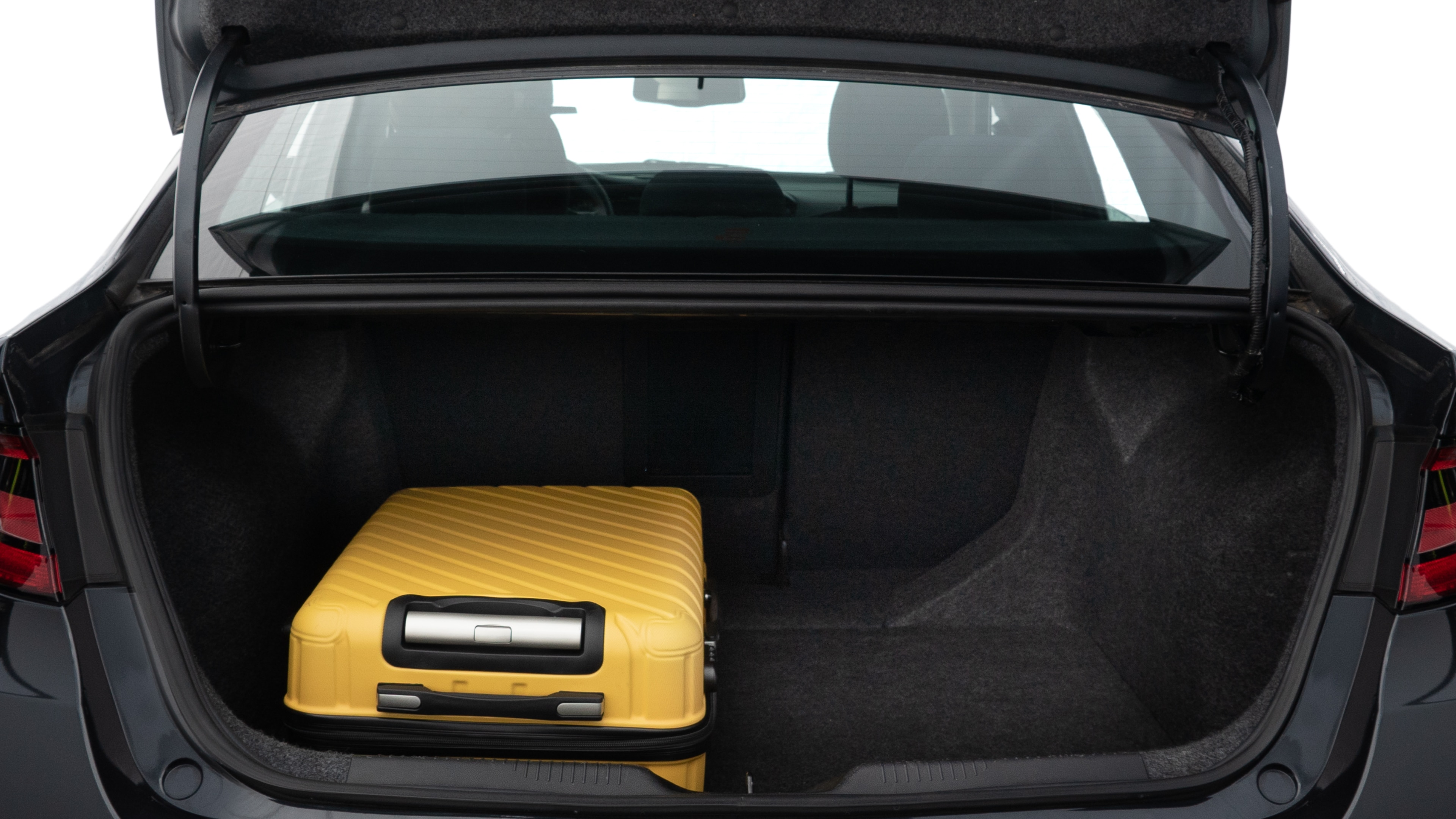 The trunk lid is open, showing full view of the trunk space. Two medium and two small suitcases are placed inside.