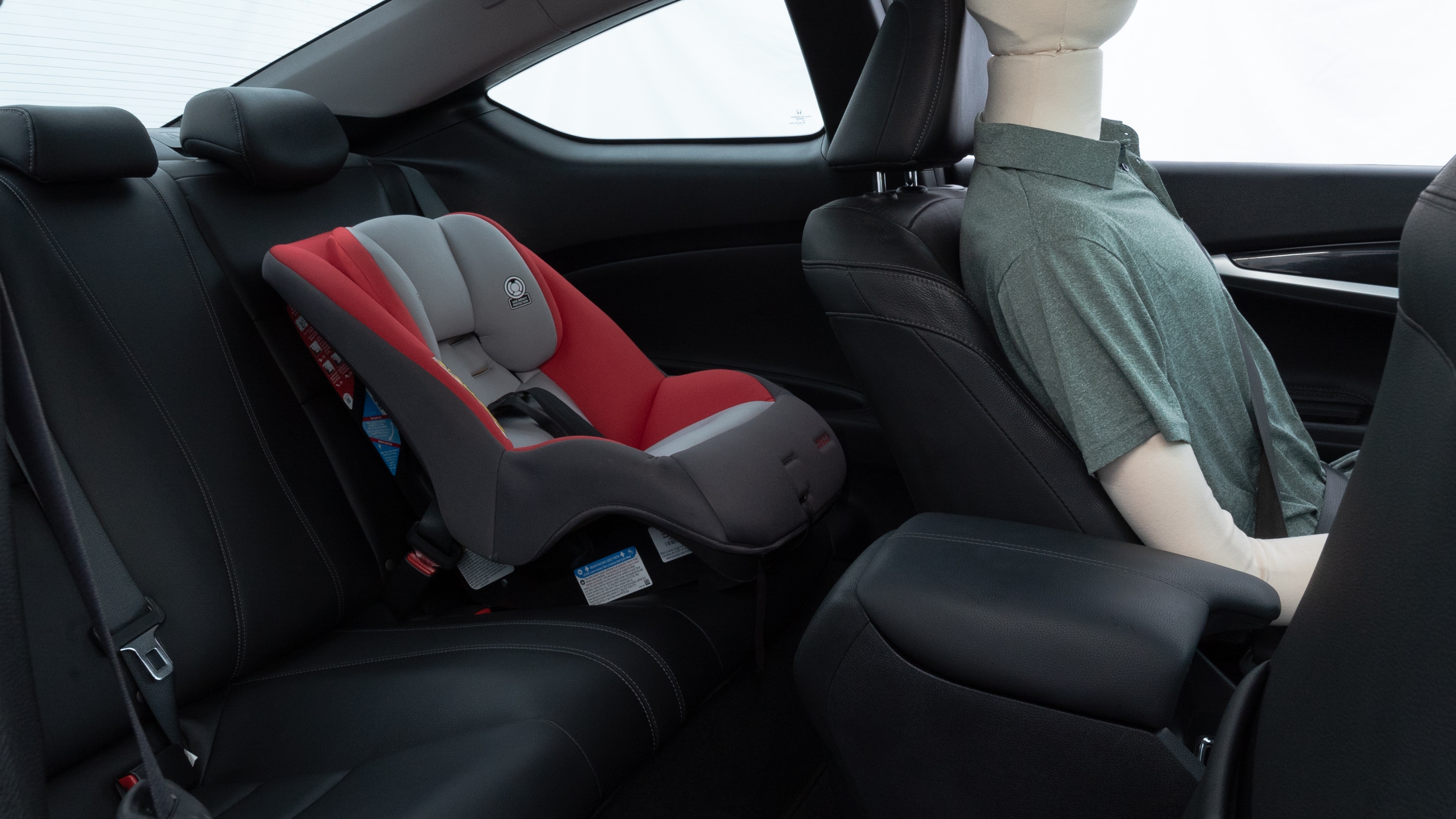 A series of second-row backseat photos is shown including one seating a baby seat and one seating a 6'1" mannequin.