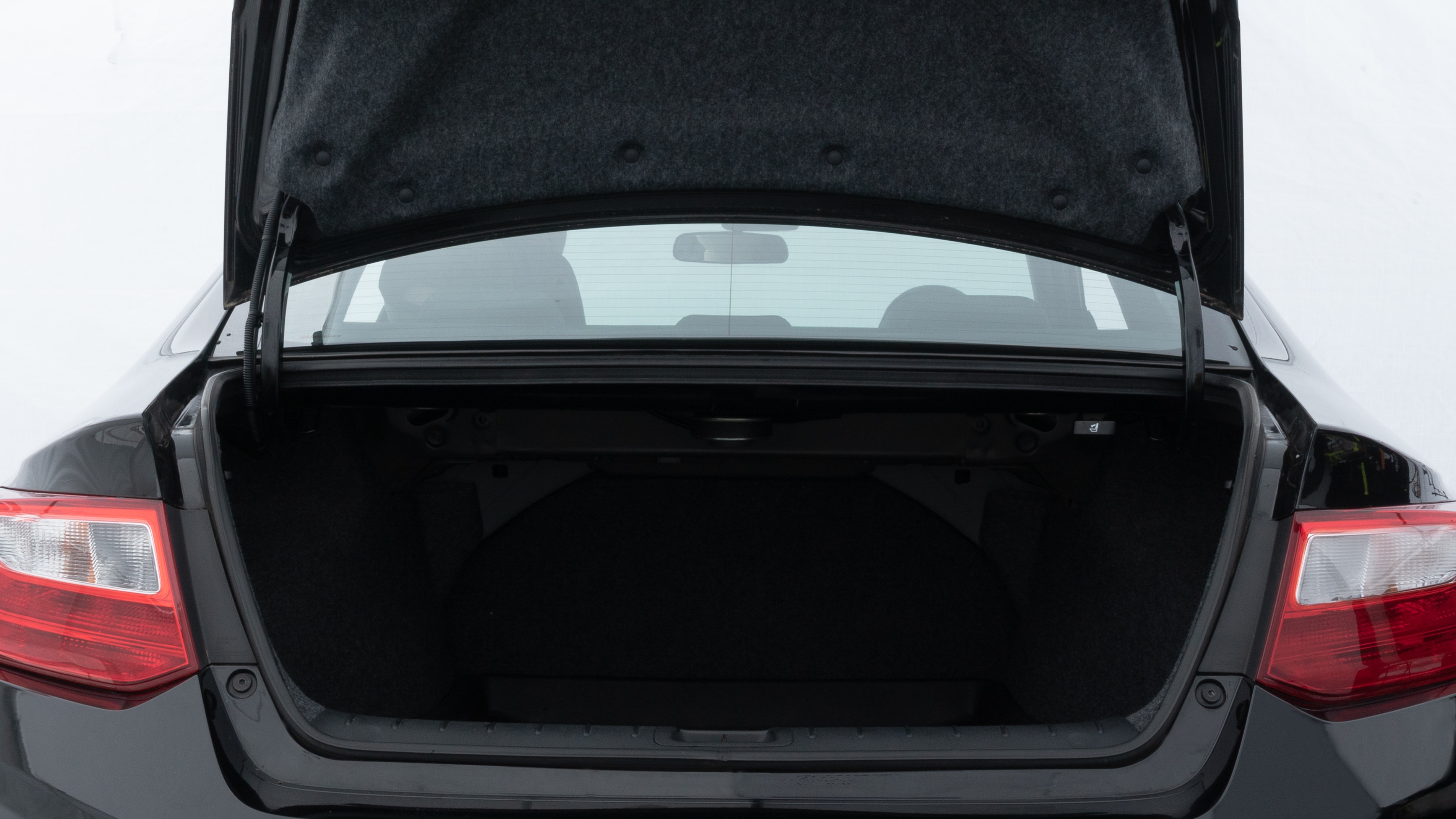 The trunk lid is open showing full view of the trunk. A baby stroller, three grocery carriers, two camping chairs in the carrying bag, and a set of golf clubs are placed inside.