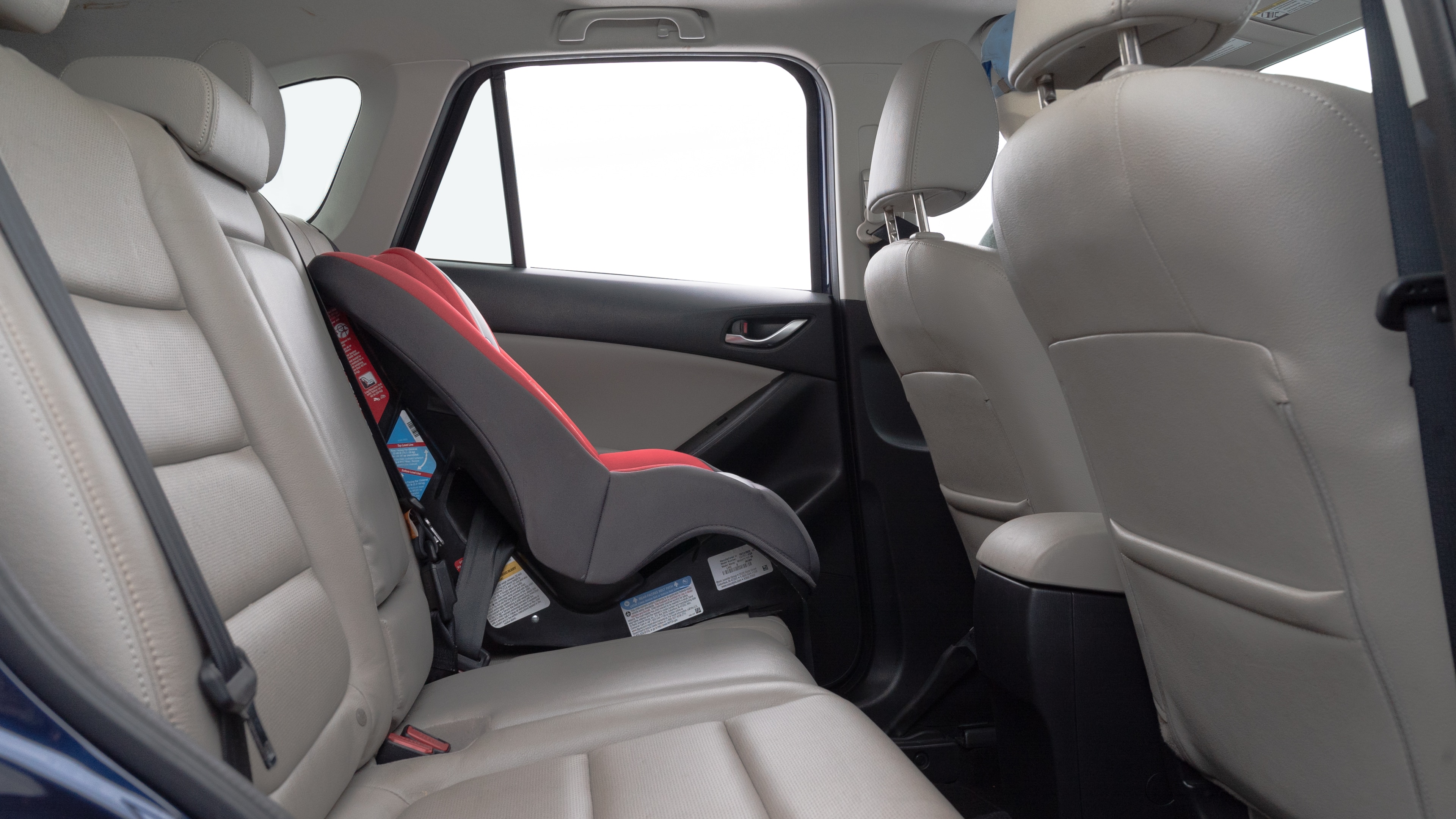 A series of second-row backseat photos is shown including one seating a baby seat and one seating a 6'1" mannequin.