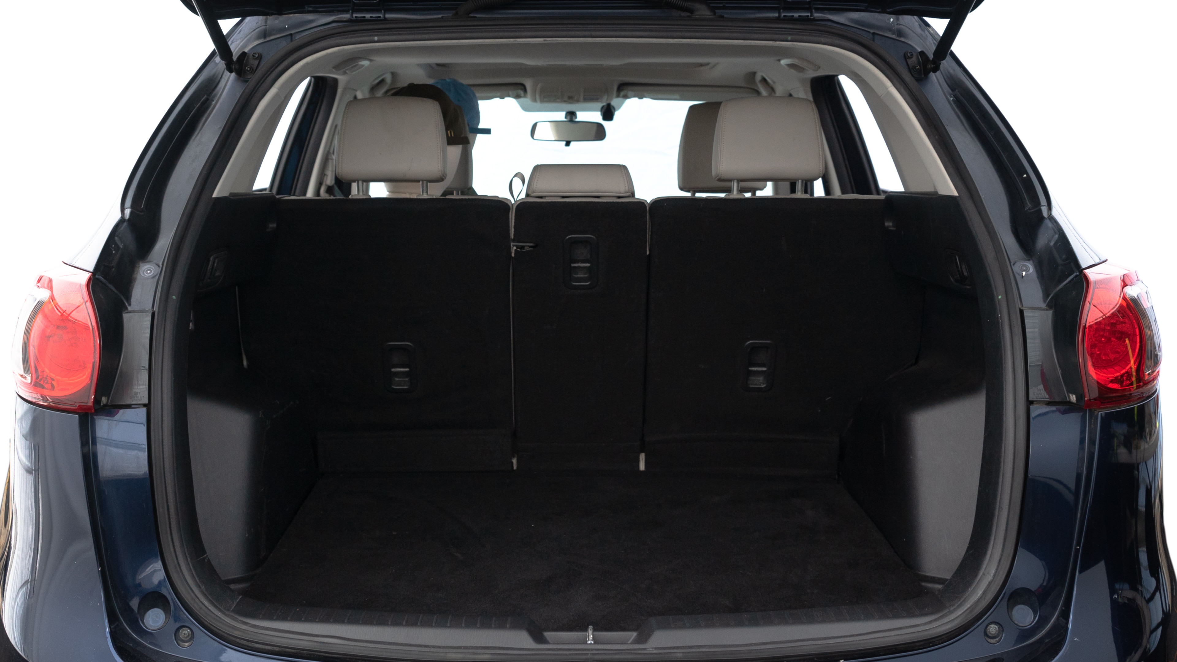 The trunk lid is open showing full view of the trunk. A baby stroller, three grocery carriers, two camping chairs in the carrying bag, and a set of golf clubs are placed inside.