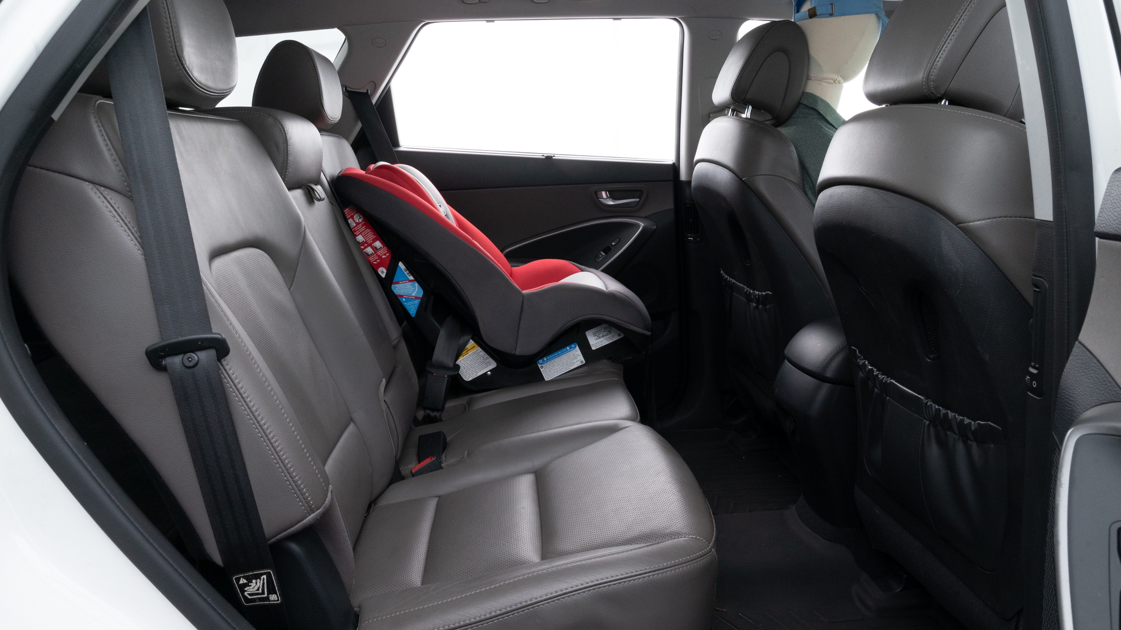 A series of second-row backseat photos is shown including one seating a baby seat and one seating a 6'1" mannequin.