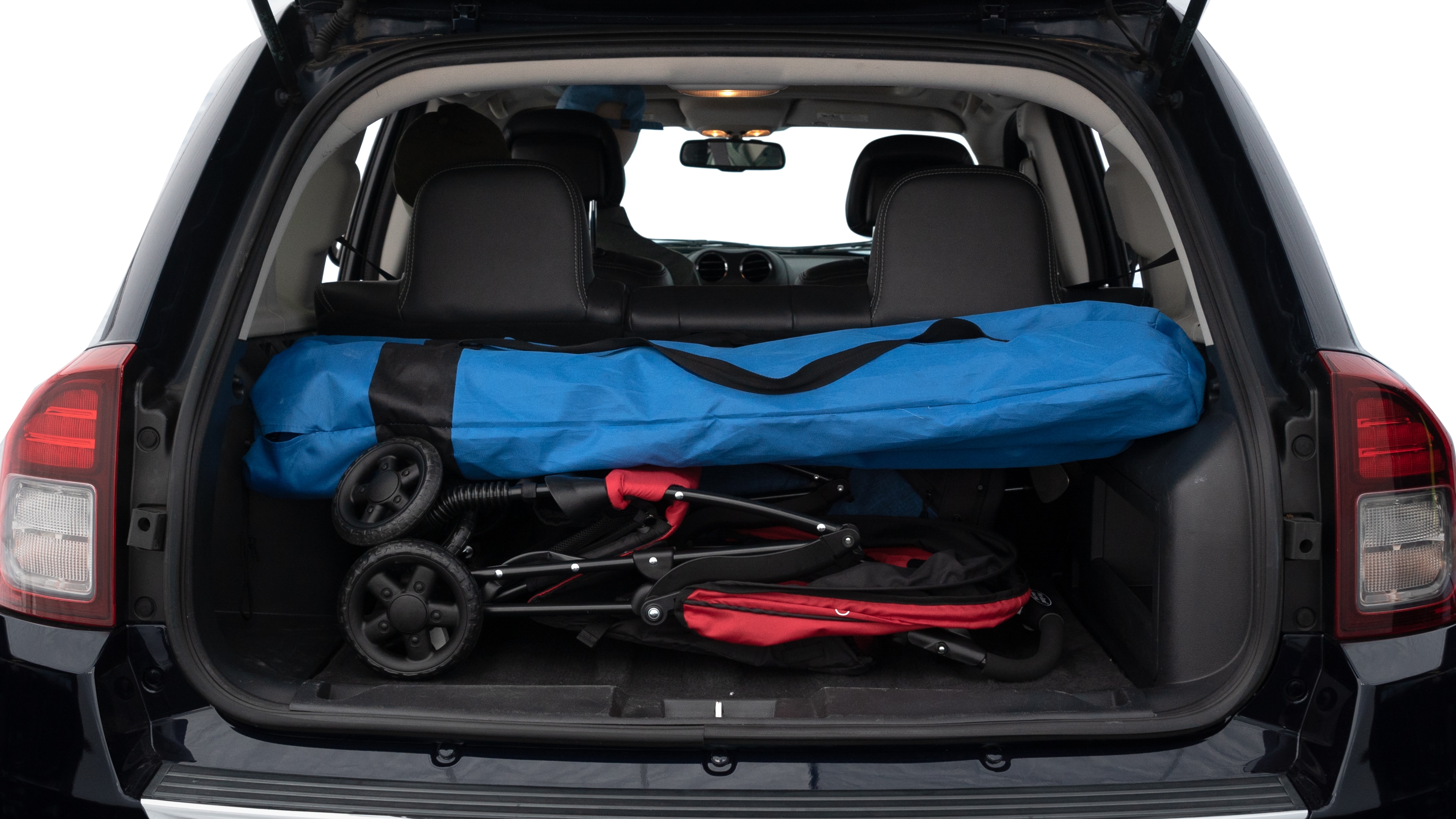 The trunk lid is open showing full view of the trunk. A baby stroller, three grocery carriers, two camping chairs in the carrying bag, and a set of golf clubs are placed inside.