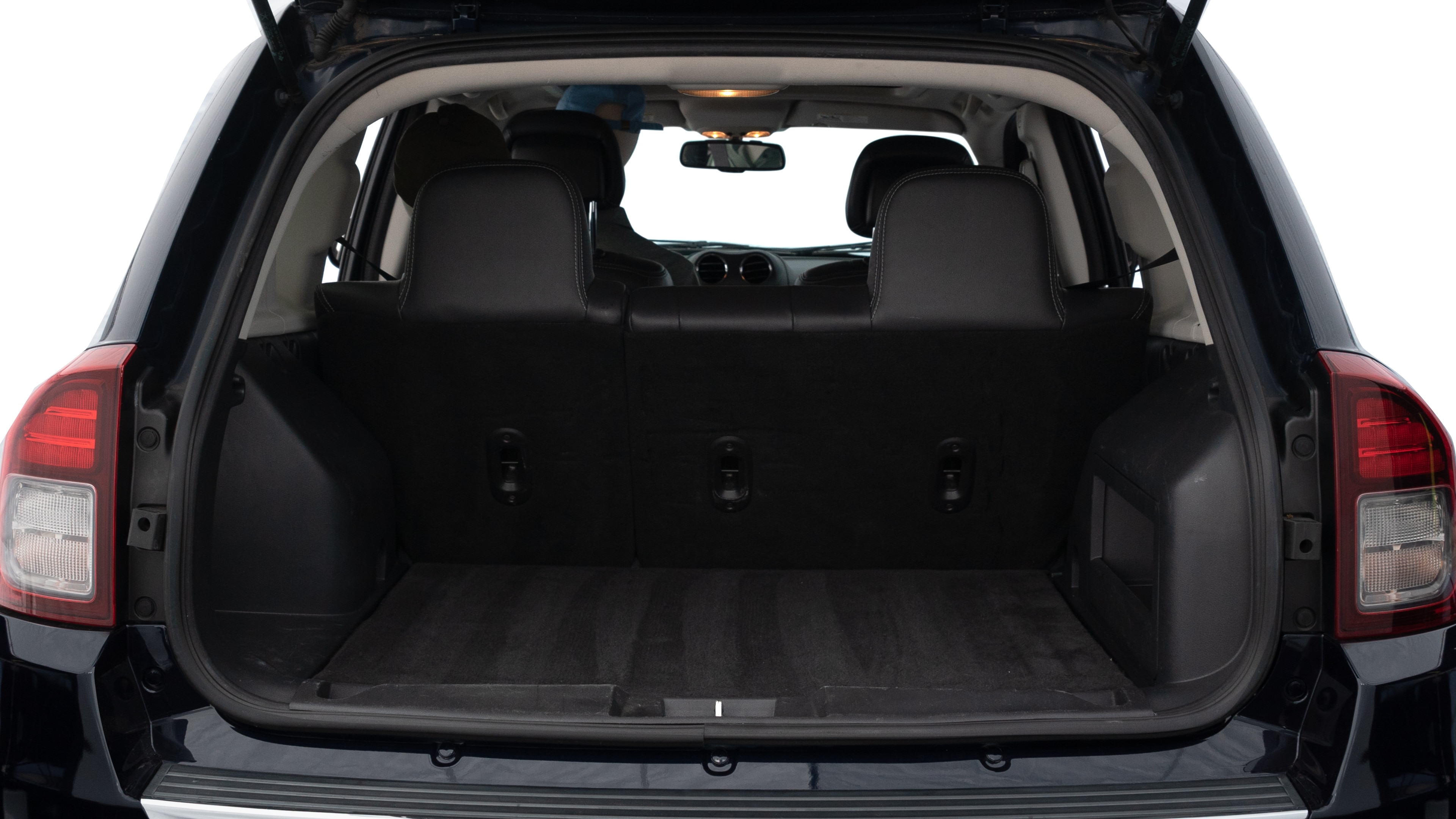 The trunk lid is open showing full view of the trunk. A baby stroller, three grocery carriers, two camping chairs in the carrying bag, and a set of golf clubs are placed inside.
