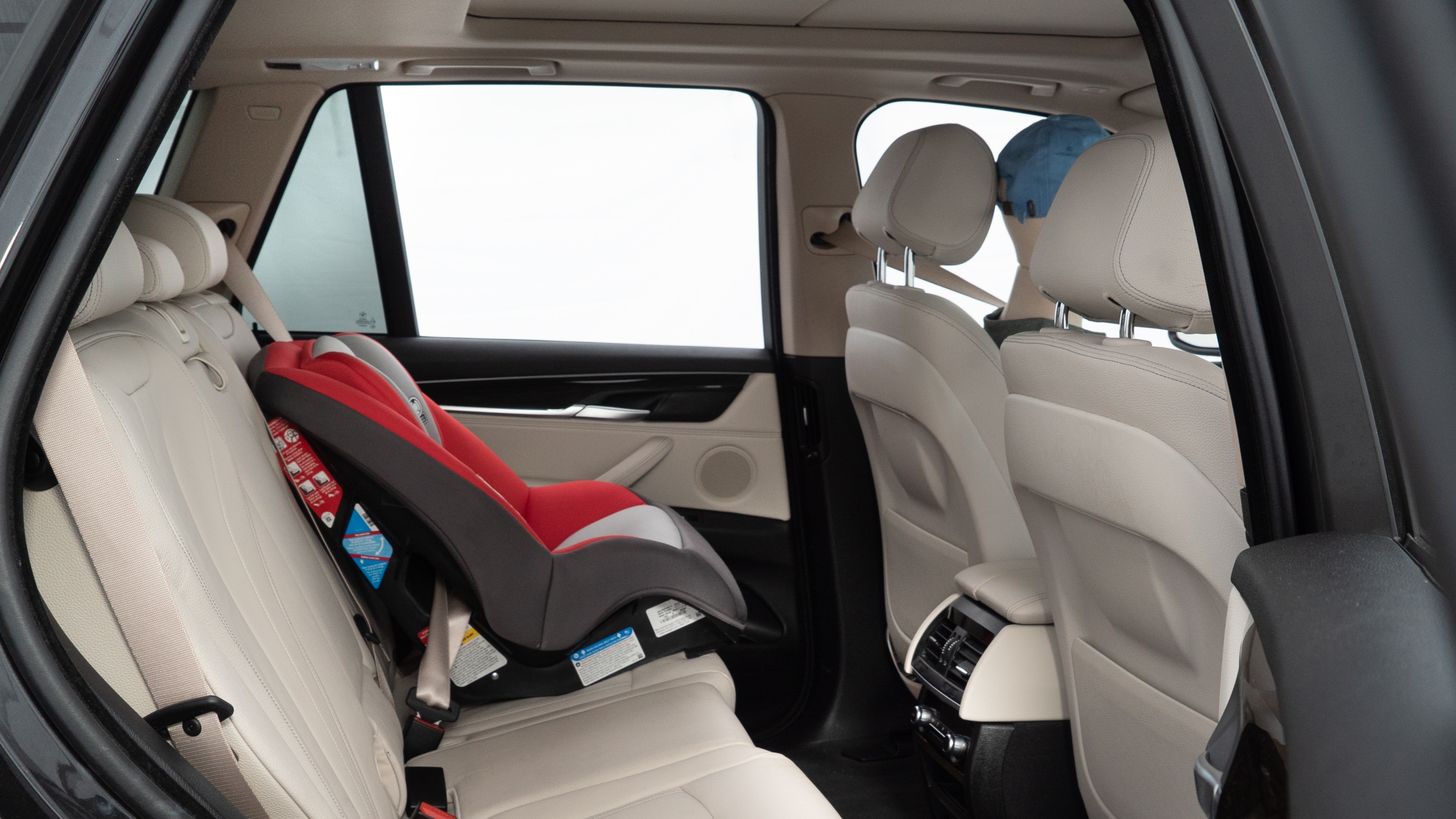 A series of second-row backseat photos is shown including one seating a baby seat and one seating a 6'1" mannequin.