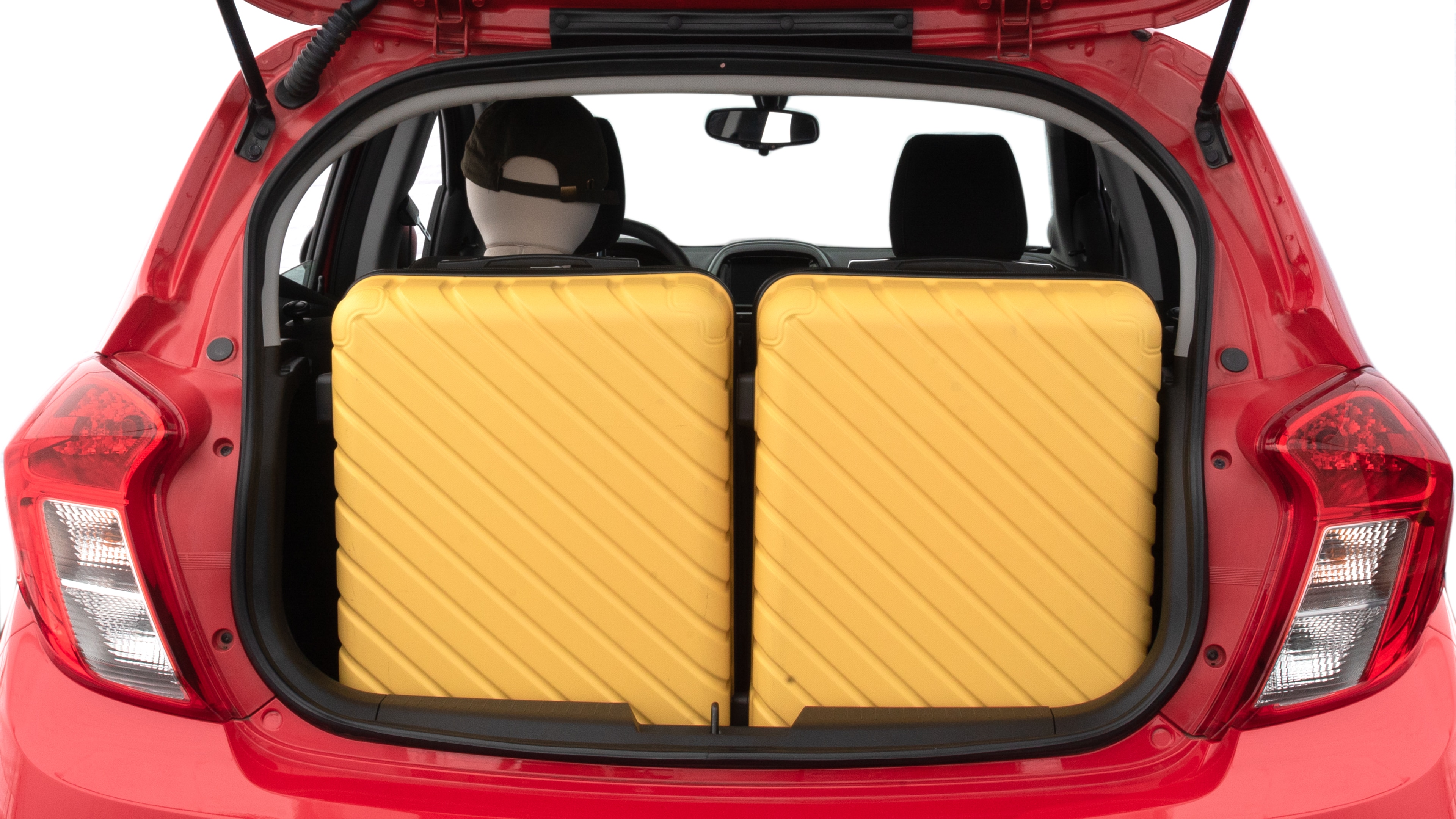 The trunk lid is open, showing full view of the trunk space. Two medium suitcases are placed inside.