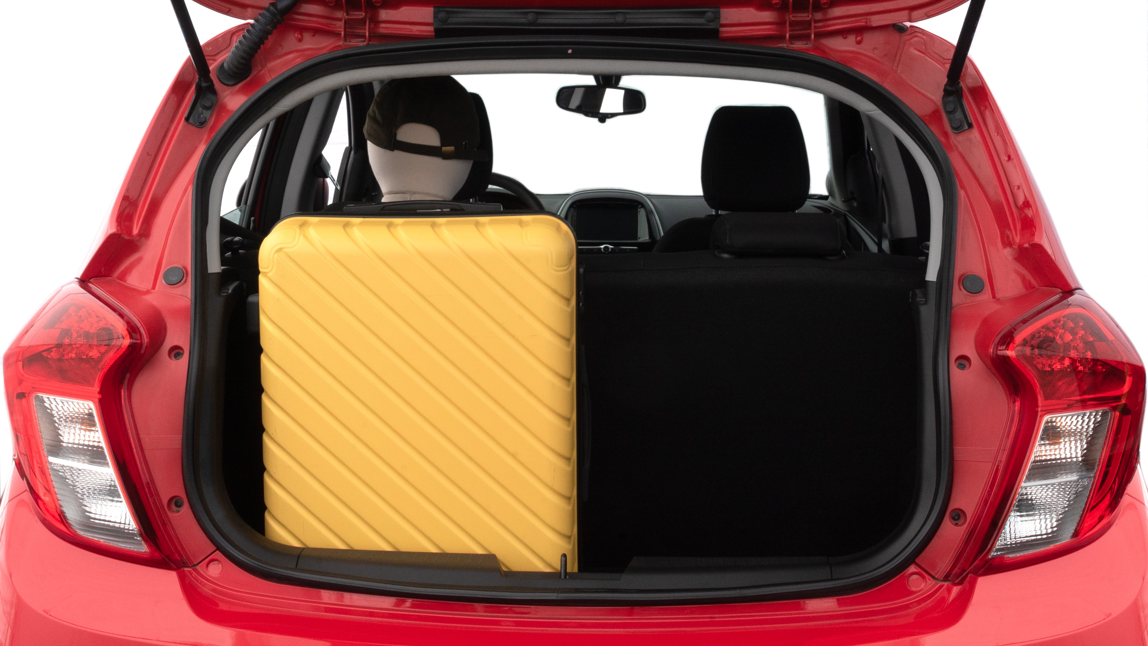 The trunk lid is open, showing full view of the trunk space. Two medium suitcases are placed inside.