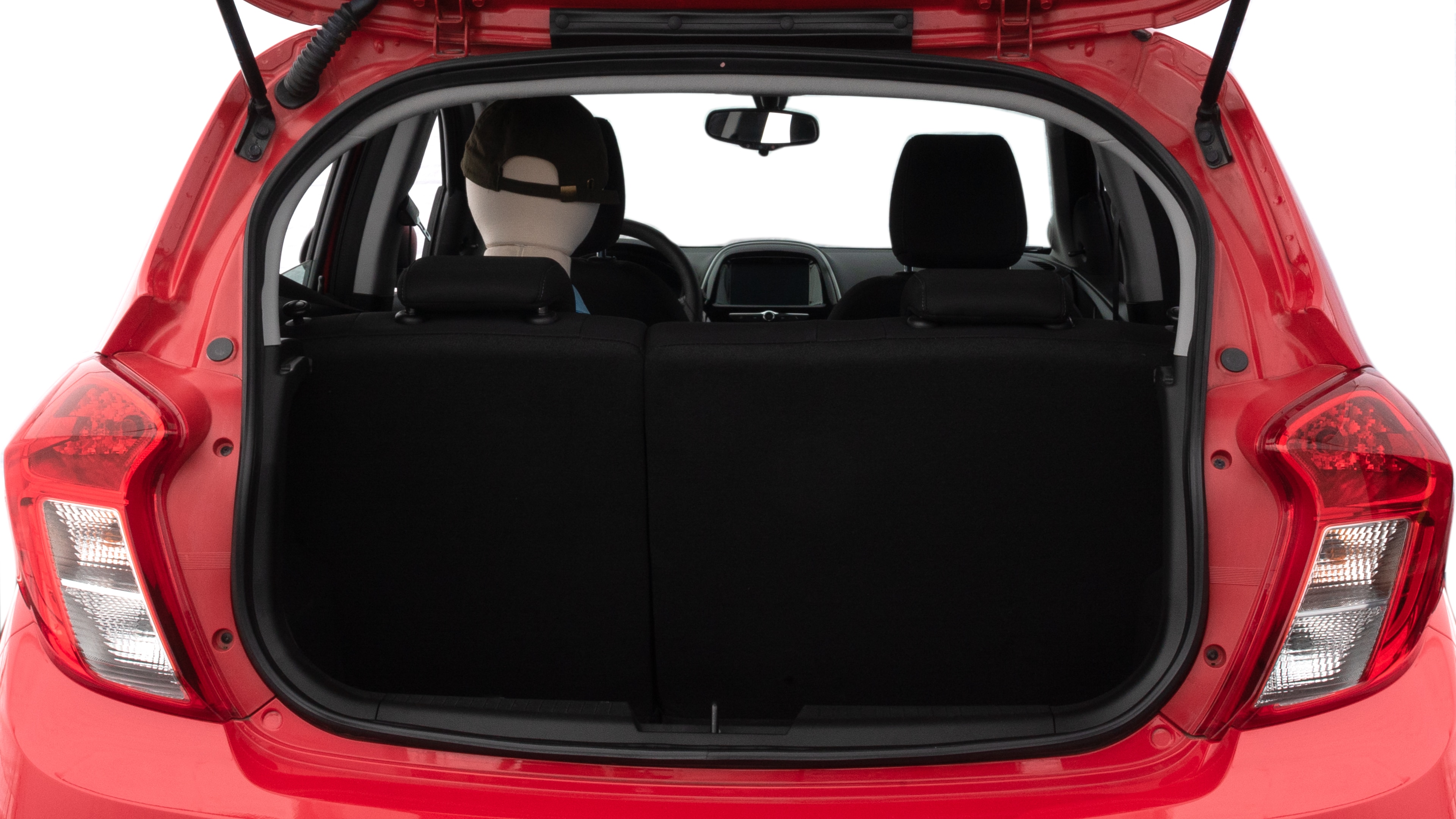 The trunk lid is open, showing full view of the trunk space. Two medium suitcases are placed inside.