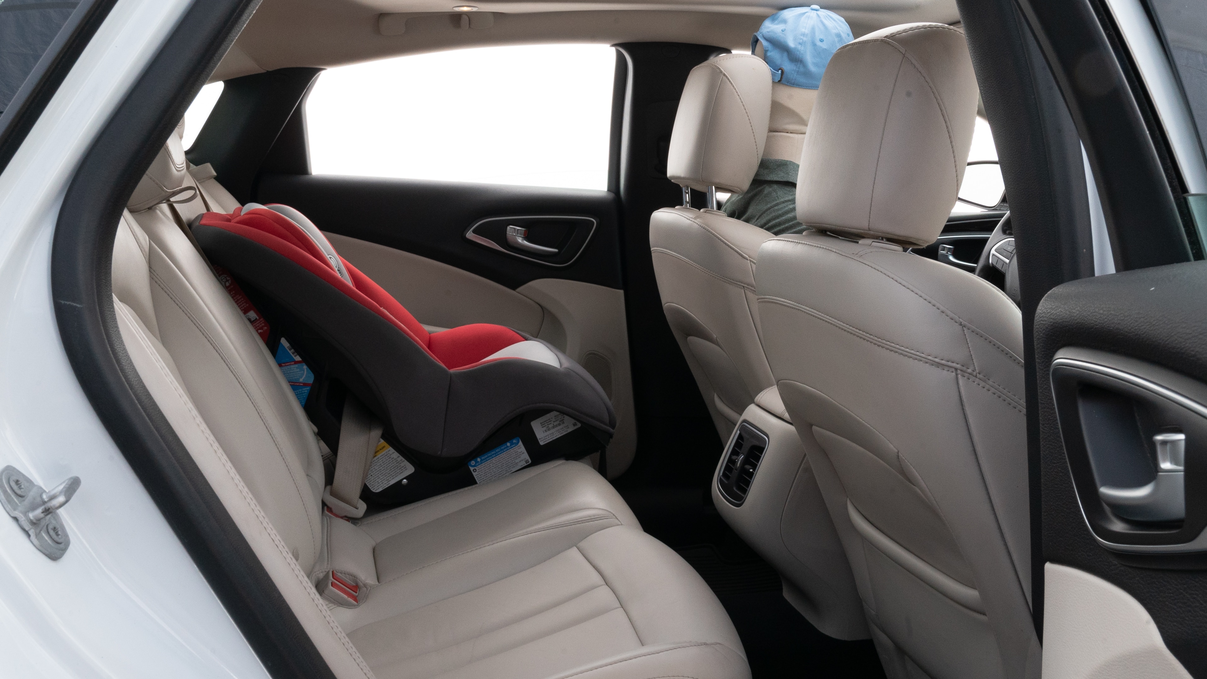 A series of second-row backseat photos is shown including one seating a baby seat and one seating a 6'1" mannequin.