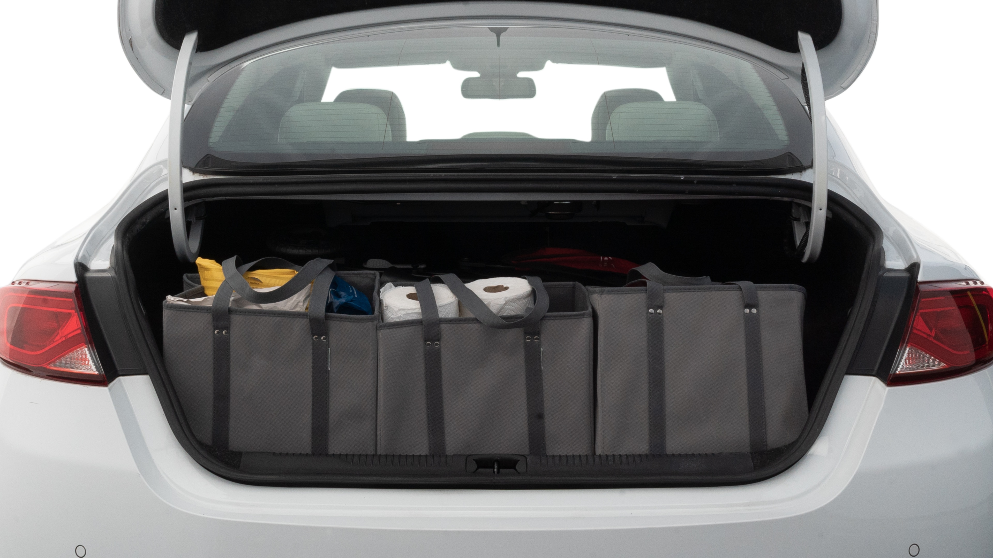 The trunk lid is open showing full view of the trunk. A baby stroller, three grocery carriers, two camping chairs in the carrying bag, and a set of golf clubs are placed inside.