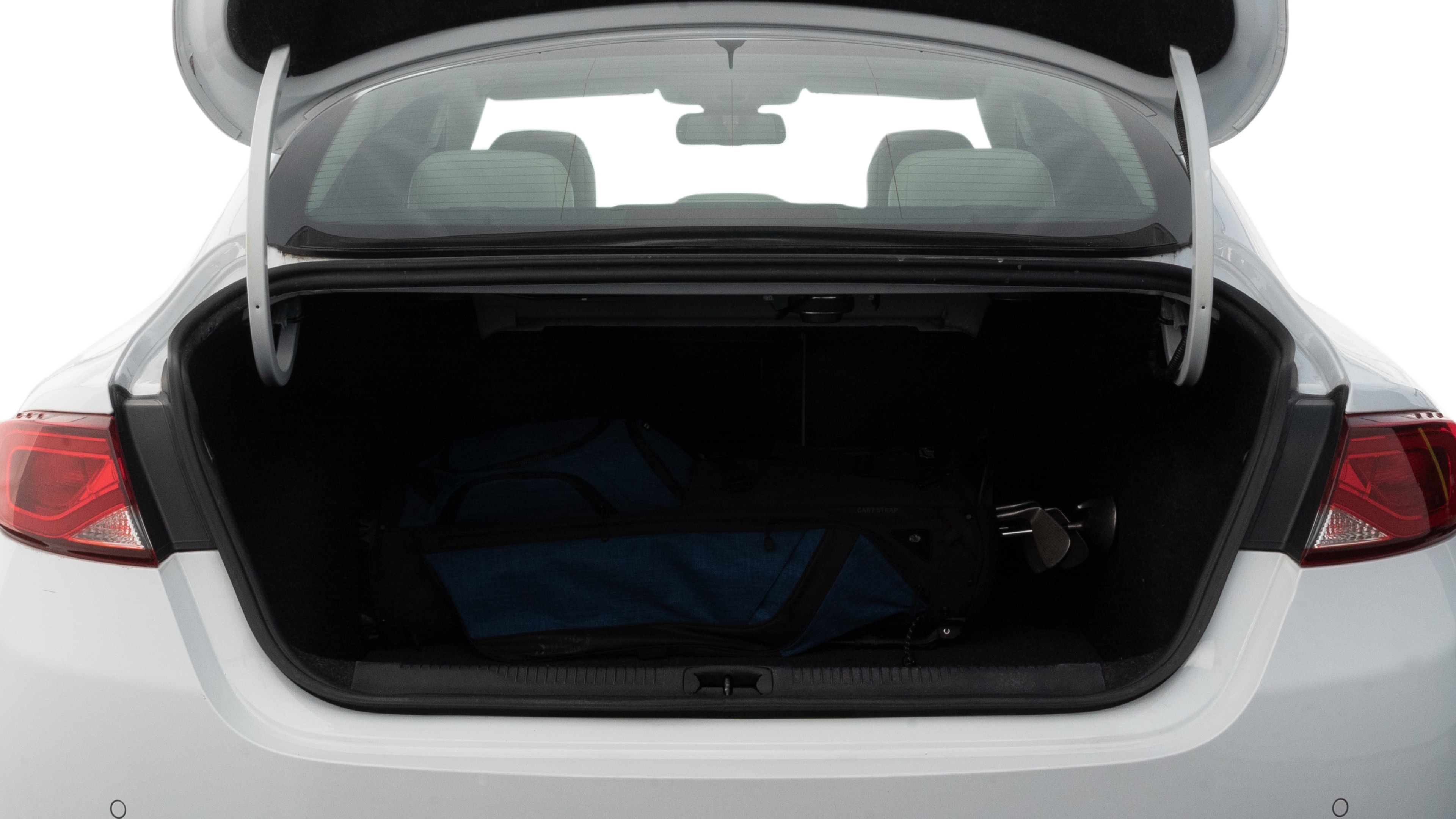 The trunk lid is open showing full view of the trunk. A baby stroller, three grocery carriers, two camping chairs in the carrying bag, and a set of golf clubs are placed inside.