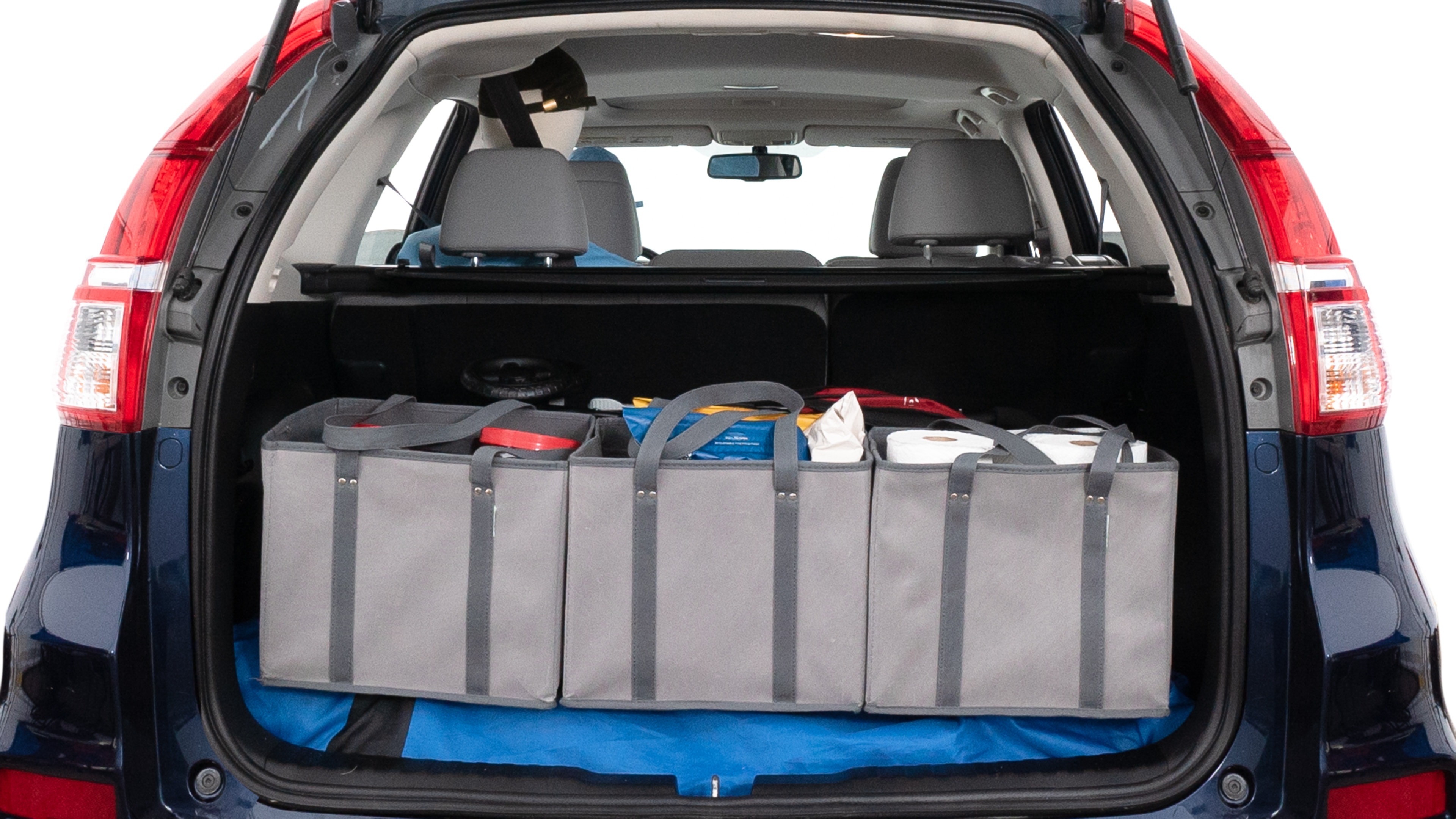 The trunk lid is open showing full view of the trunk. A baby stroller, three grocery carriers, two camping chairs in the carrying bag, and a set of golf clubs are placed inside.