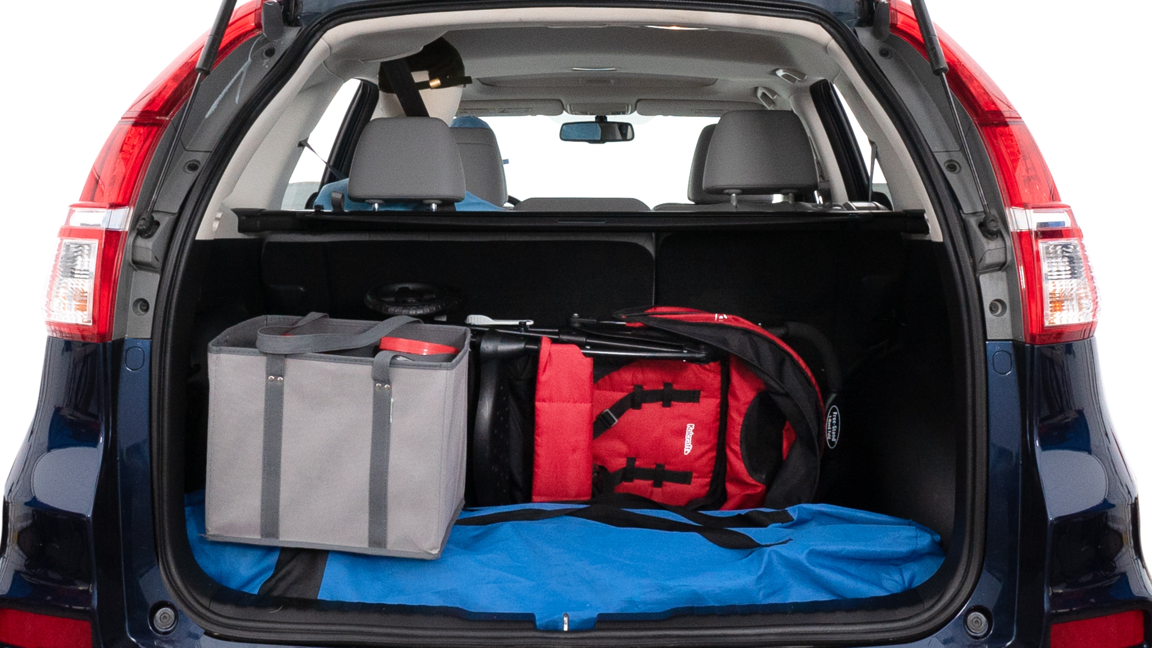 The trunk lid is open showing full view of the trunk. A baby stroller, three grocery carriers, two camping chairs in the carrying bag, and a set of golf clubs are placed inside.