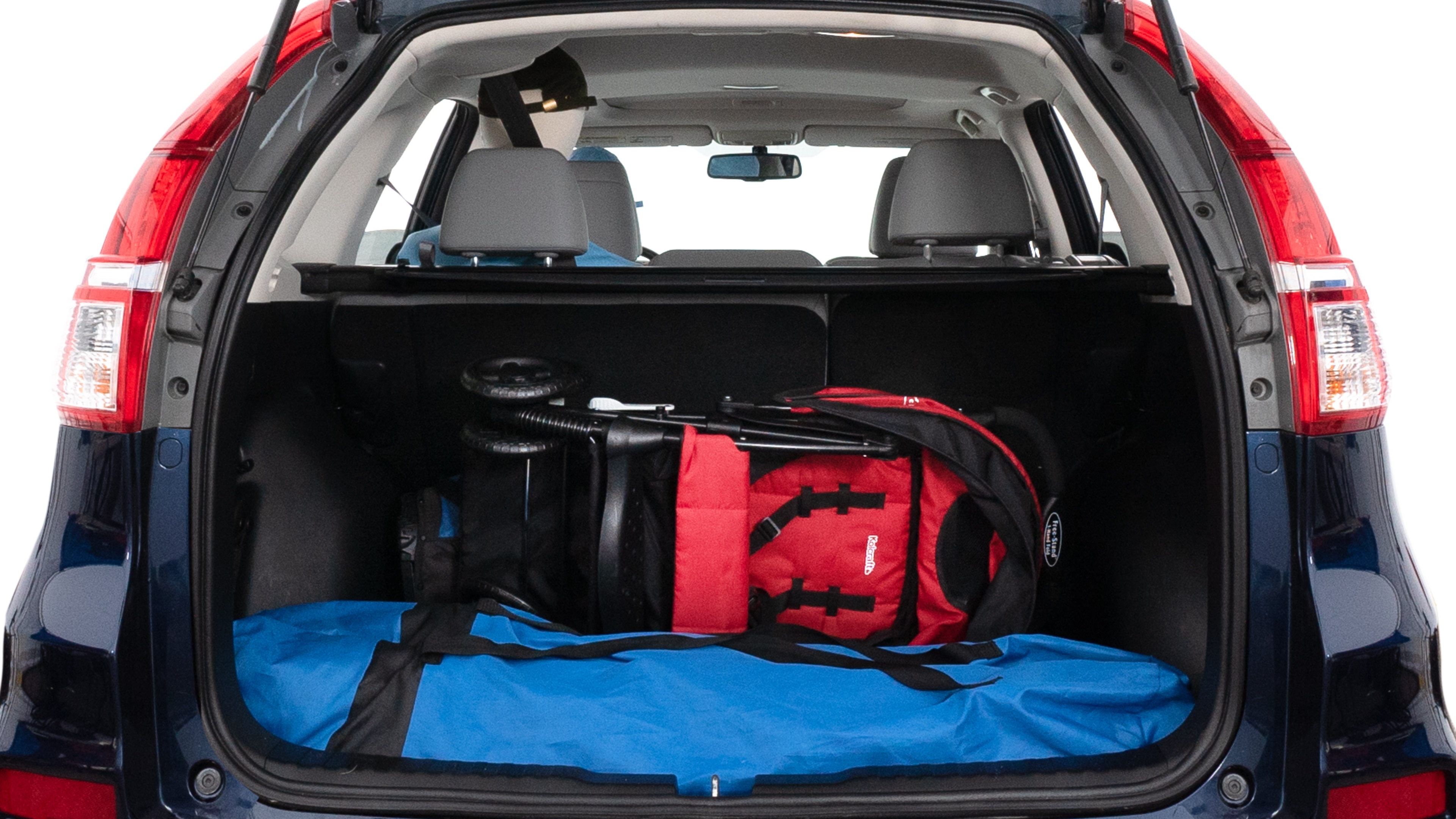 The trunk lid is open showing full view of the trunk. A baby stroller, three grocery carriers, two camping chairs in the carrying bag, and a set of golf clubs are placed inside.