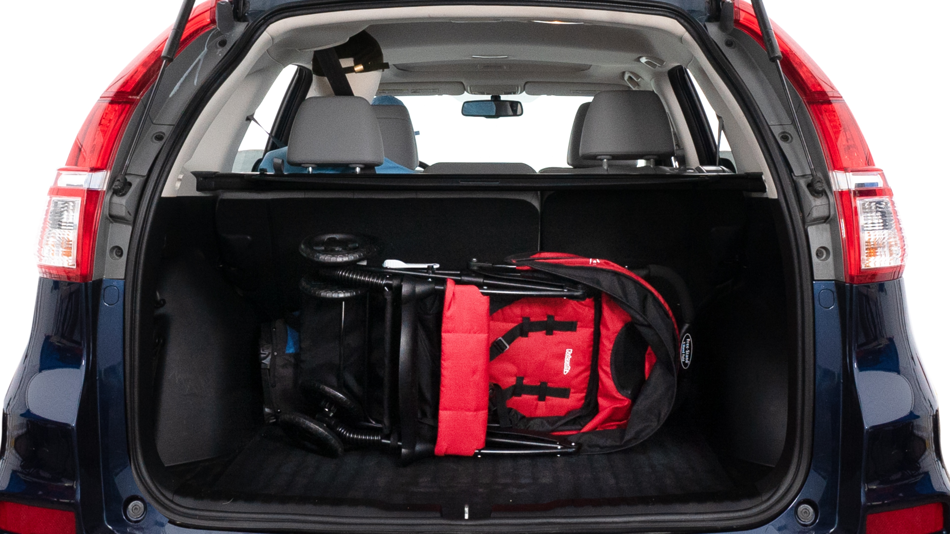 The trunk lid is open showing full view of the trunk. A baby stroller, three grocery carriers, two camping chairs in the carrying bag, and a set of golf clubs are placed inside.