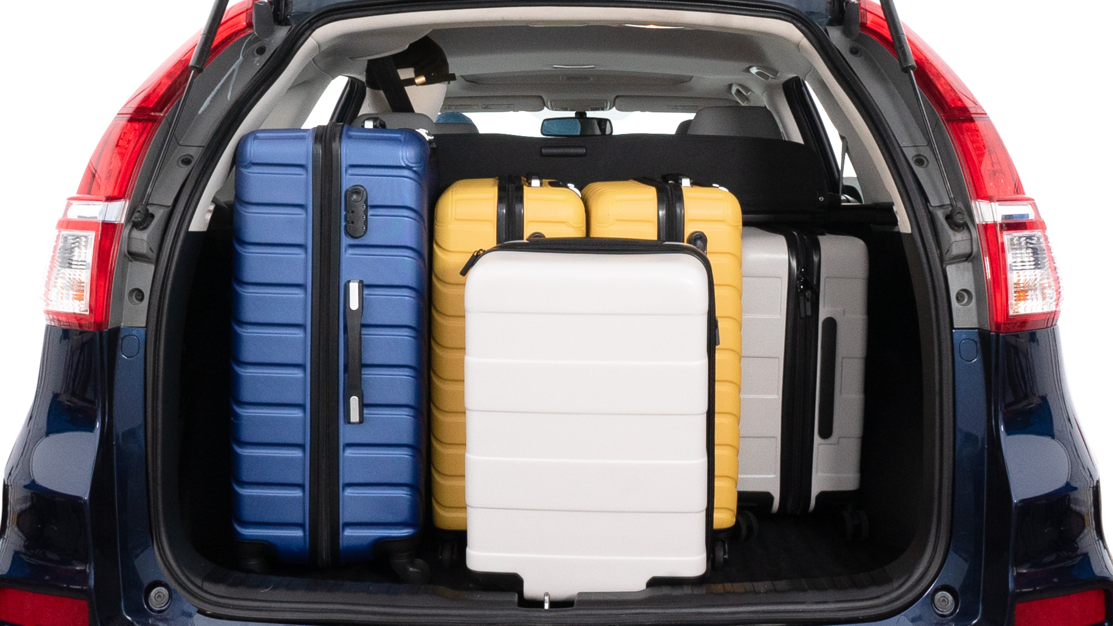 The trunk lid is open, showing full view of the trunk space. One large, two medium and two small suitcases are placed inside.