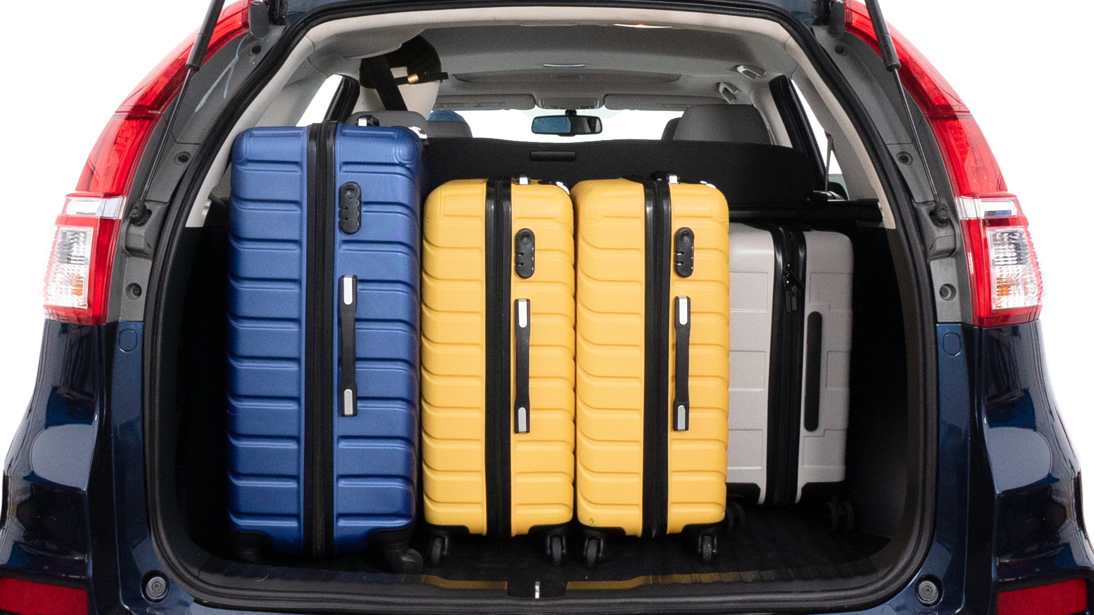 The trunk lid is open, showing full view of the trunk space. One large, two medium and two small suitcases are placed inside.