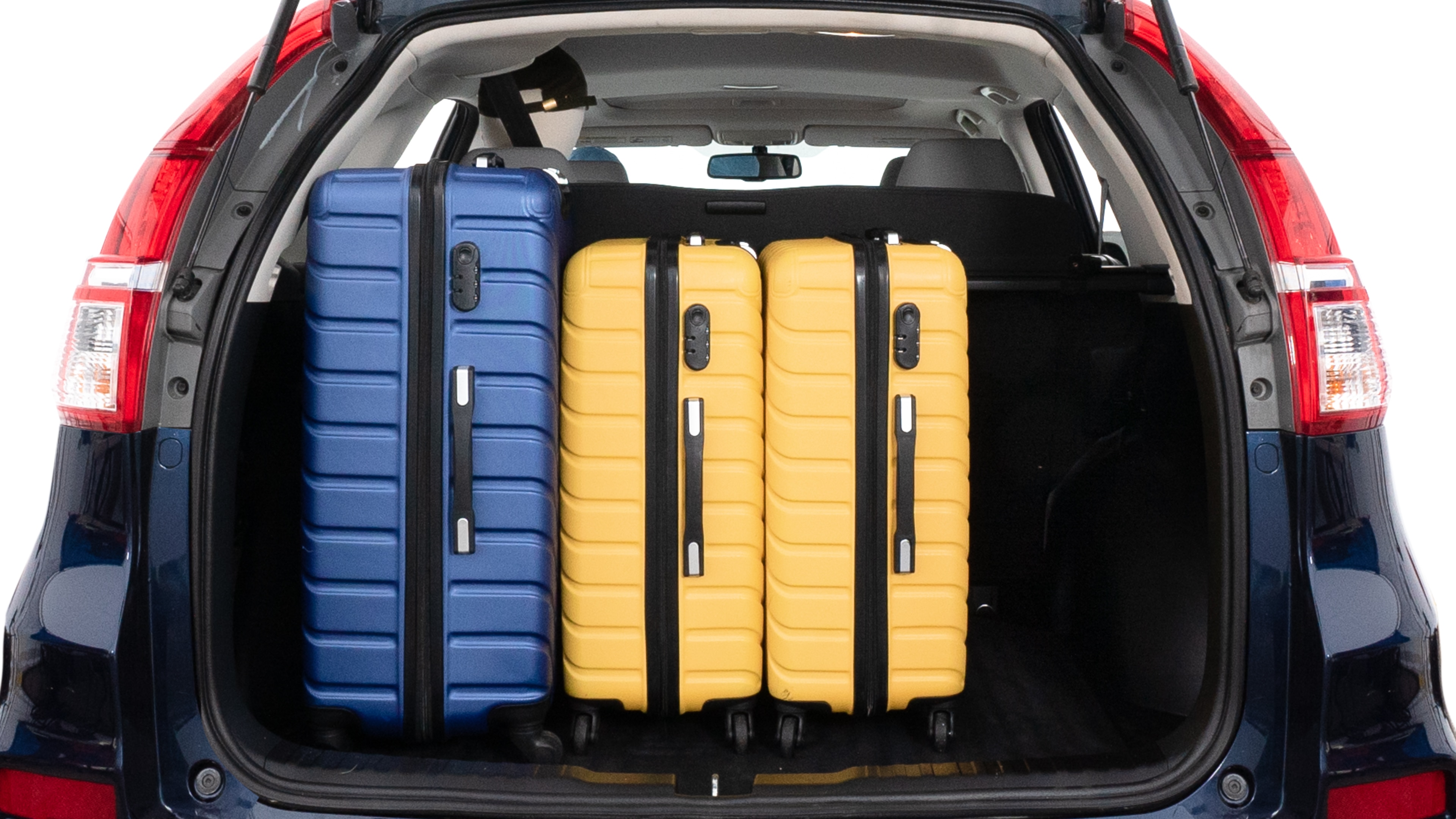 The trunk lid is open, showing full view of the trunk space. One large, two medium and two small suitcases are placed inside.