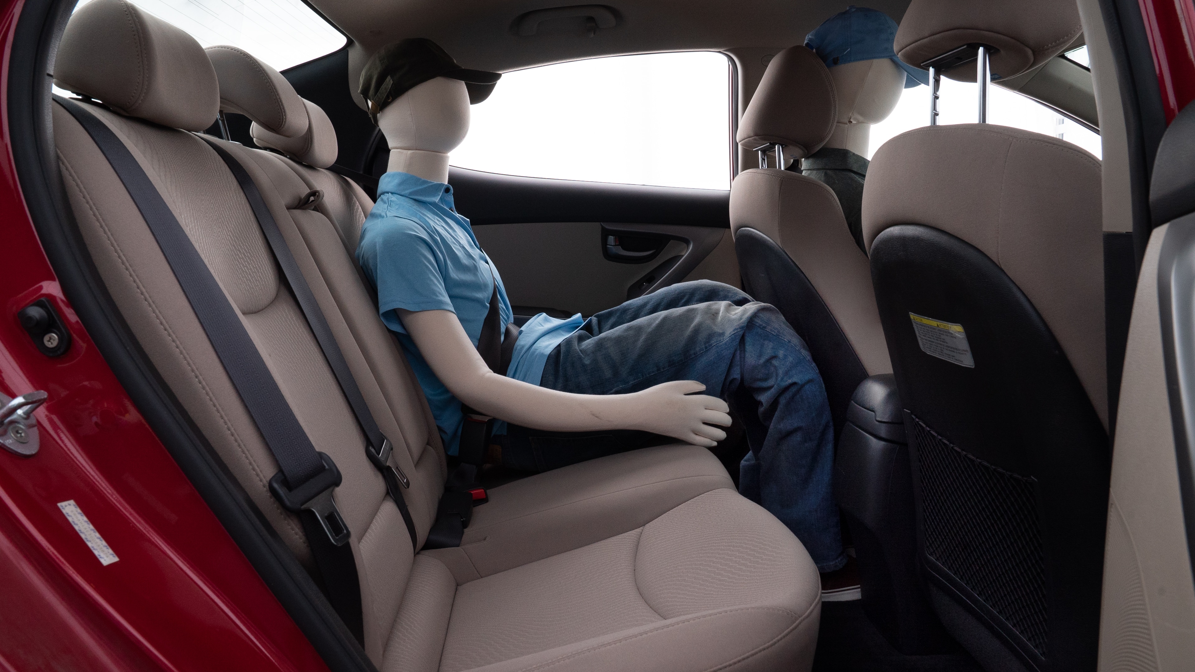 A series of second-row backseat photos is shown including one seating a baby seat and one seating a 6'1" mannequin.