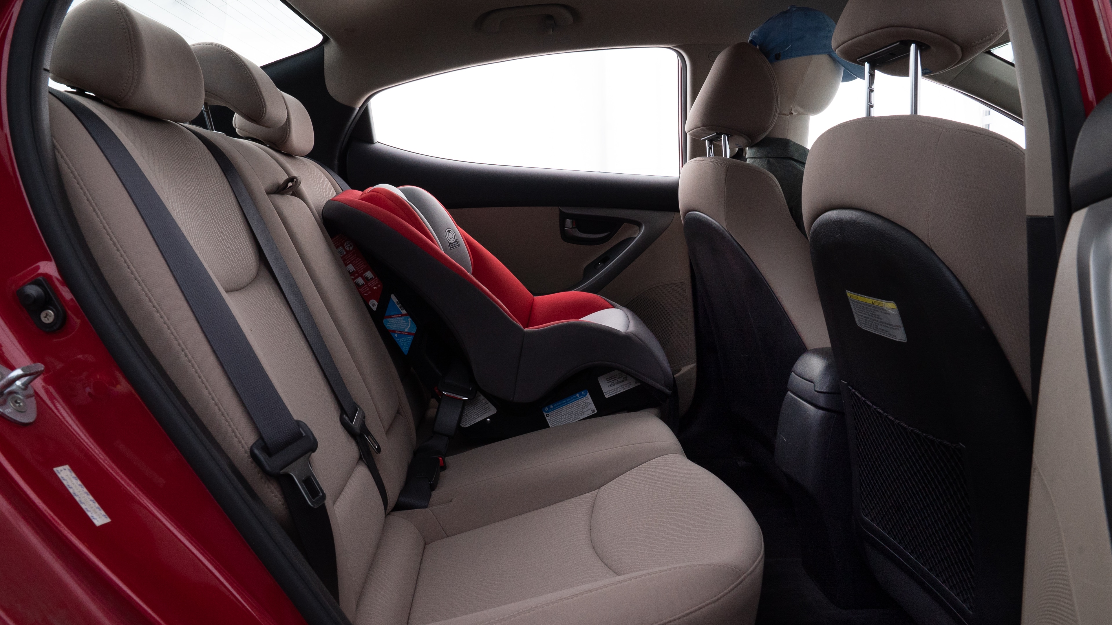 A series of second-row backseat photos is shown including one seating a baby seat and one seating a 6'1" mannequin.
