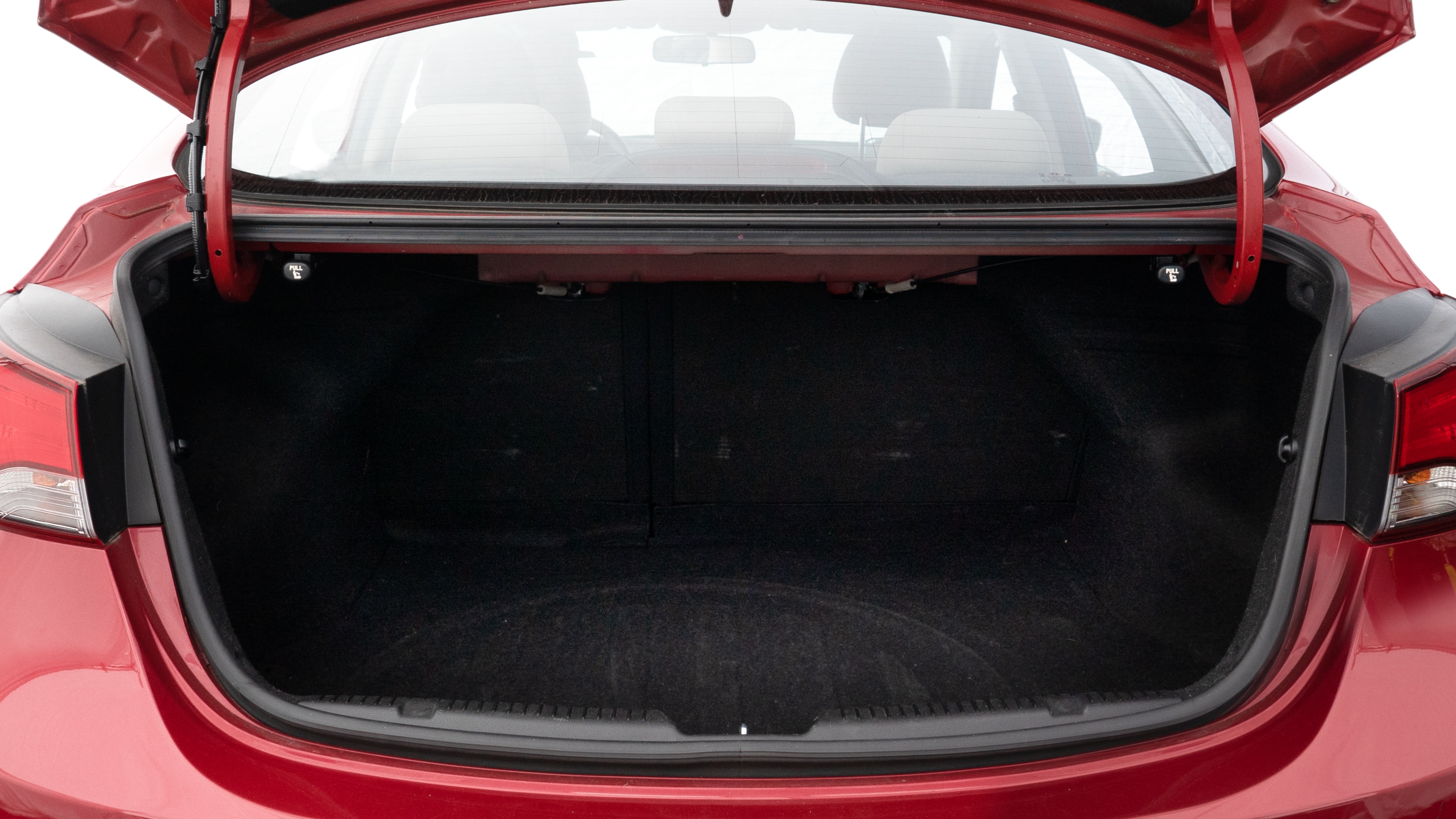 The trunk lid is open, showing full view of the trunk space. Two medium and two small suitcases are placed inside.