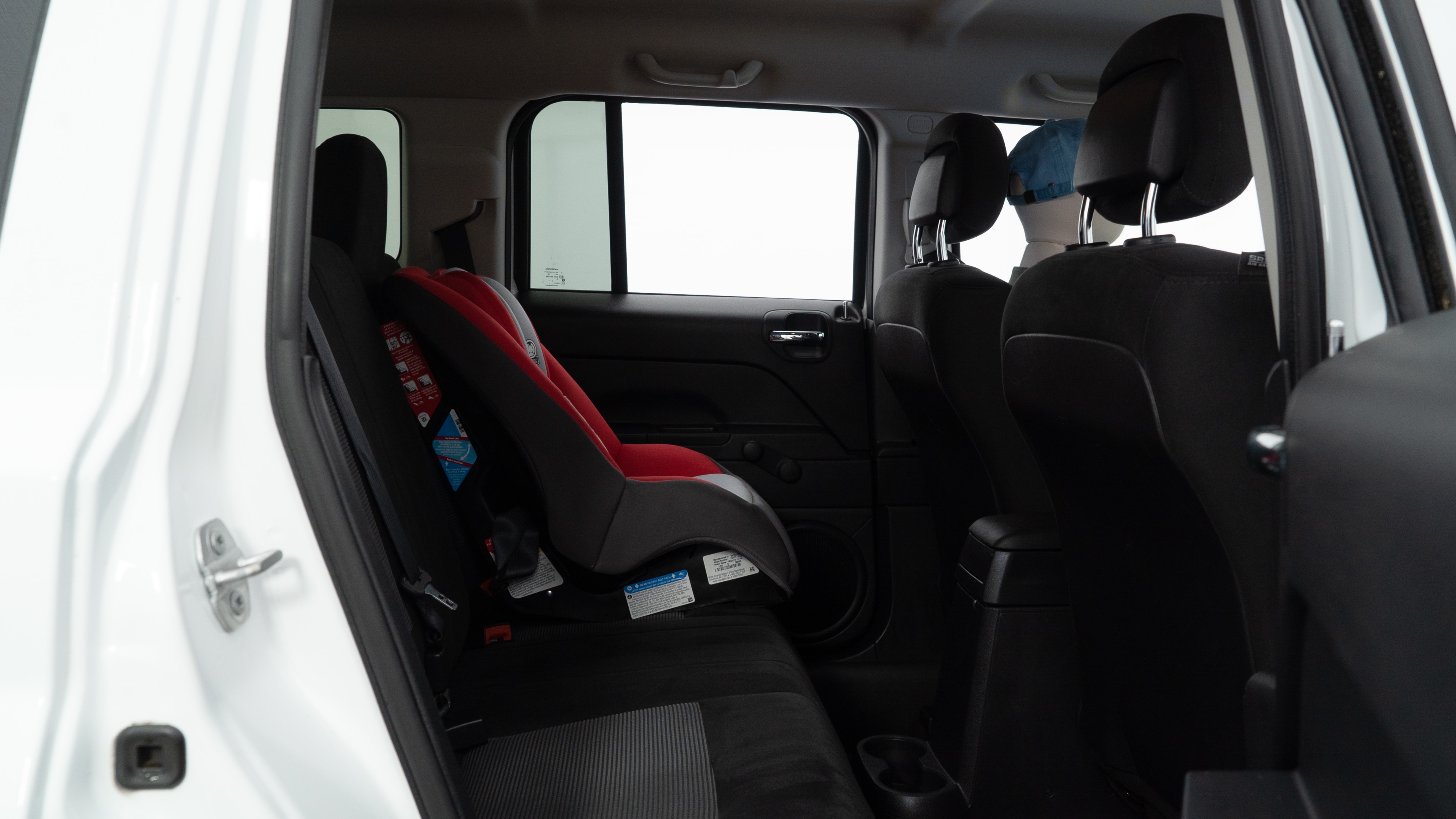 A series of second-row backseat photos is shown including one seating a baby seat and one seating a 6'1" mannequin.