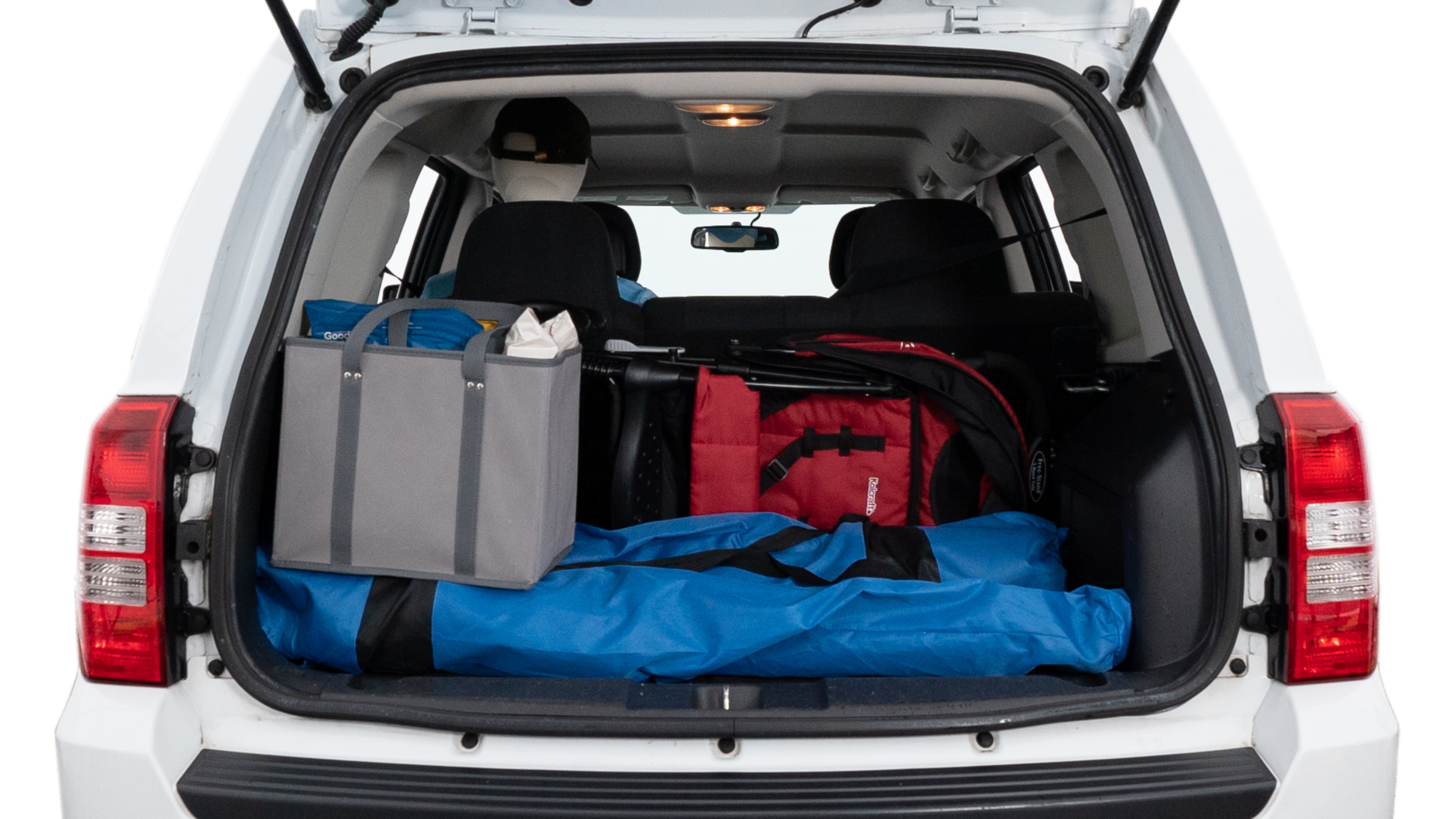 The trunk lid is open showing full view of the trunk. A baby stroller, three grocery carriers, two camping chairs in the carrying bag, and a set of golf clubs are placed inside.