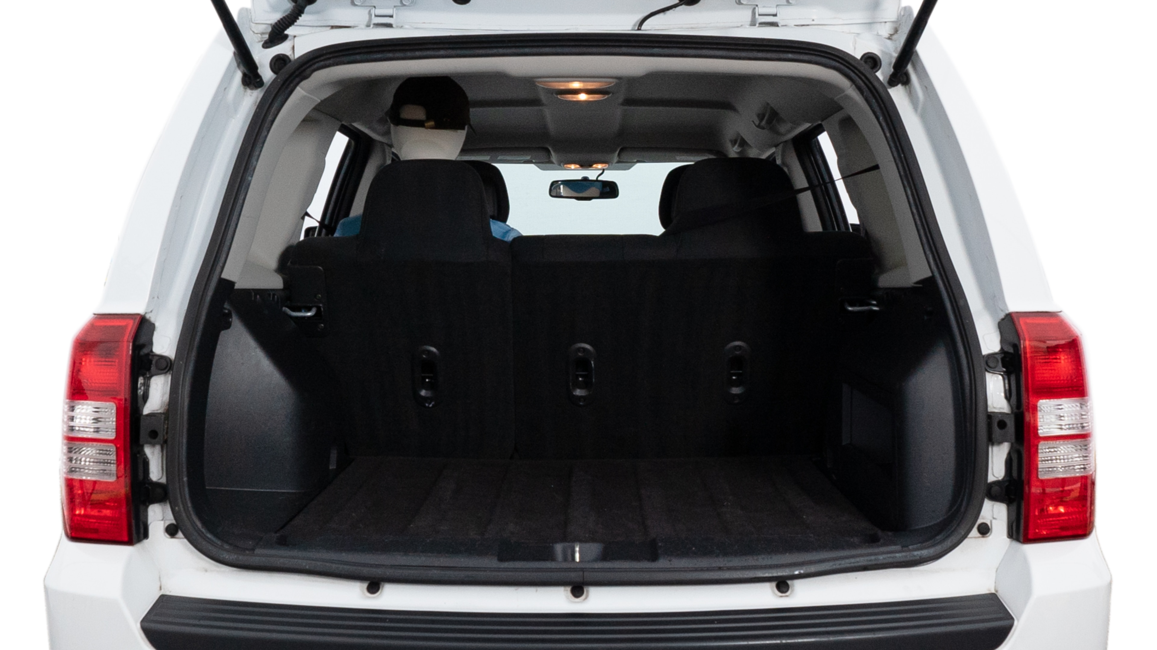 The trunk lid is open, showing full view of the trunk space. Two medium and two small suitcases are placed inside.
