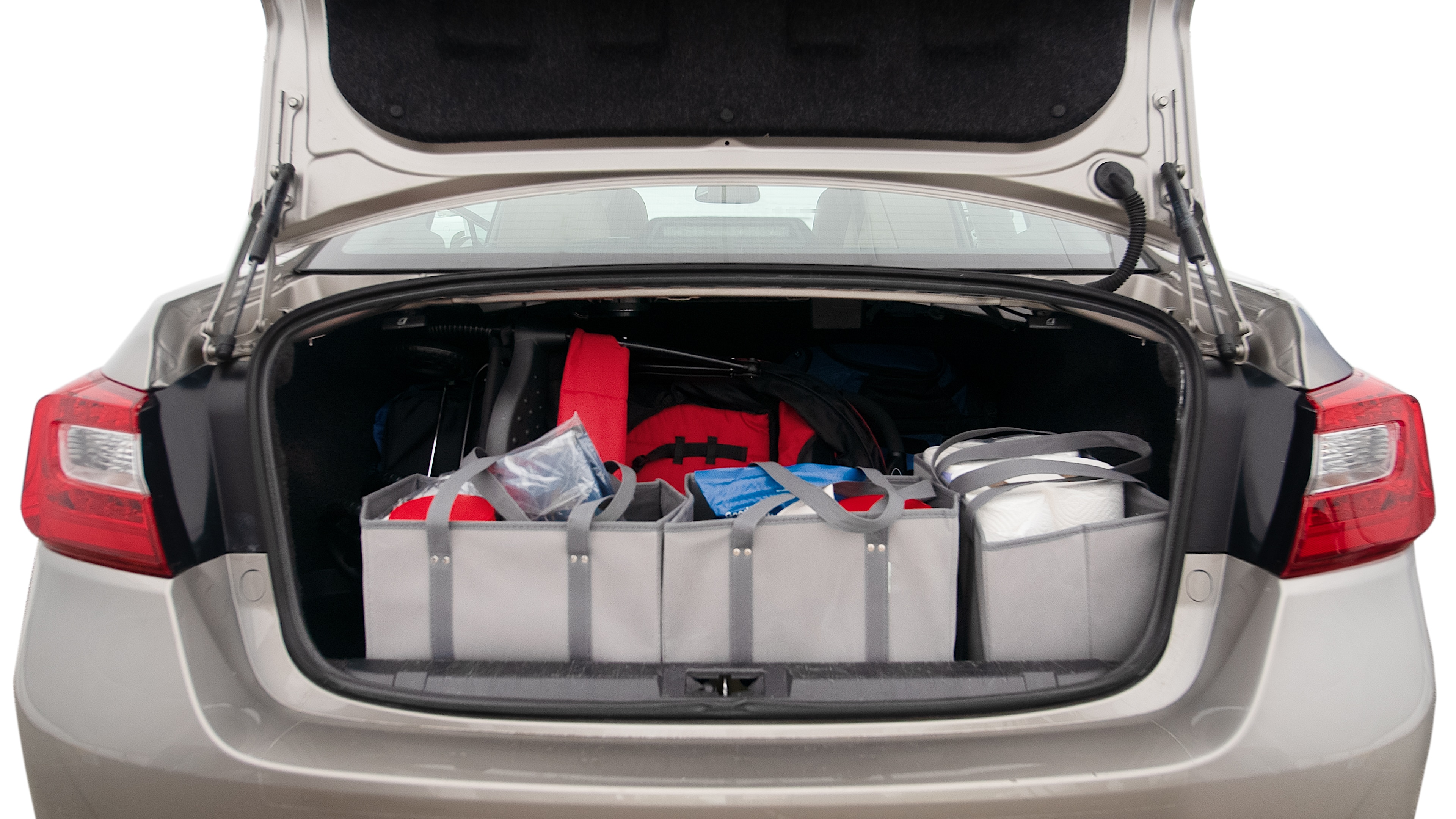 The trunk lid is open showing full view of the trunk. A baby stroller, three grocery carriers, two camping chairs in the carrying bag, and a set of golf clubs are placed inside.