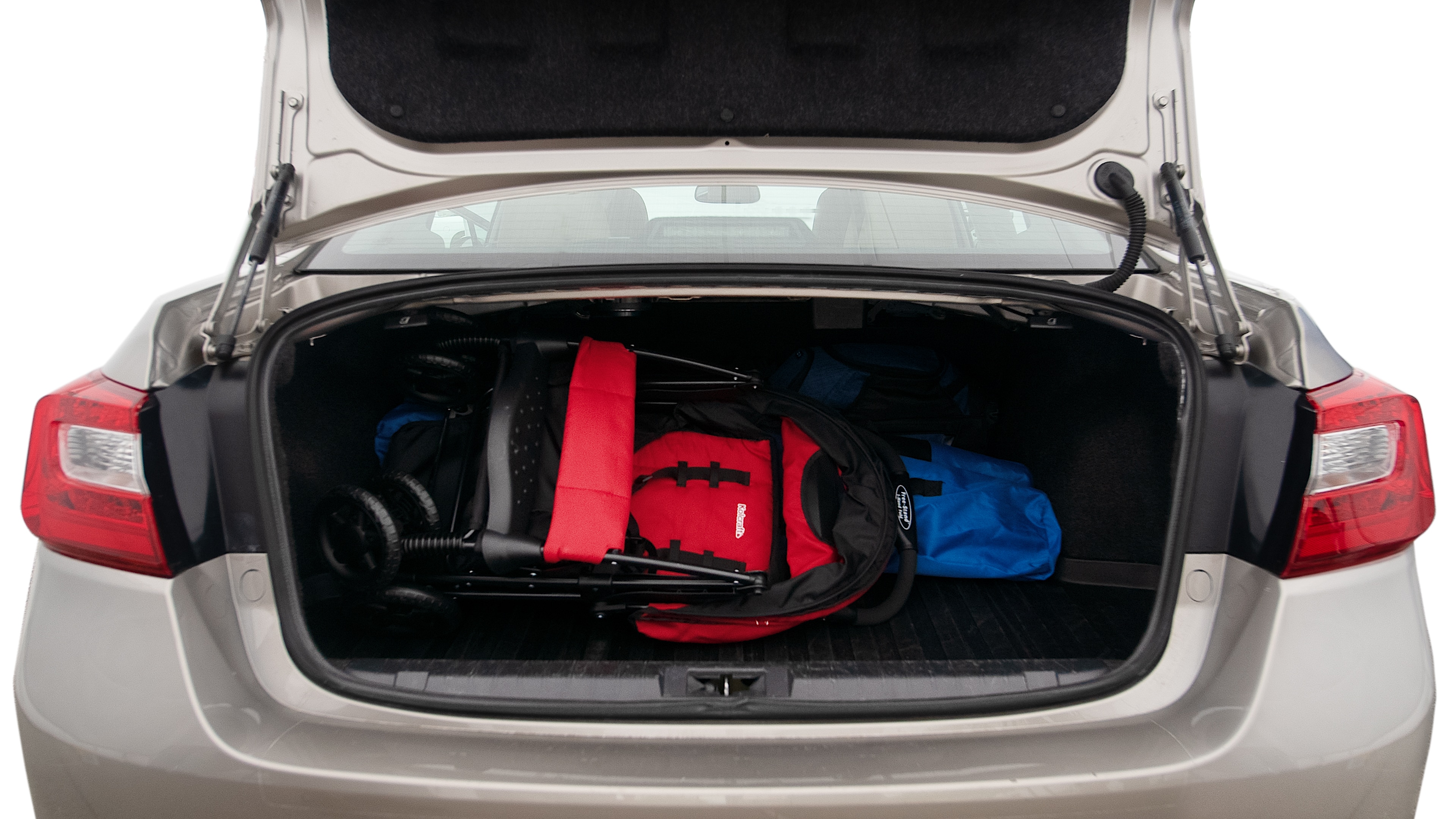 The trunk lid is open showing full view of the trunk. A baby stroller, three grocery carriers, two camping chairs in the carrying bag, and a set of golf clubs are placed inside.