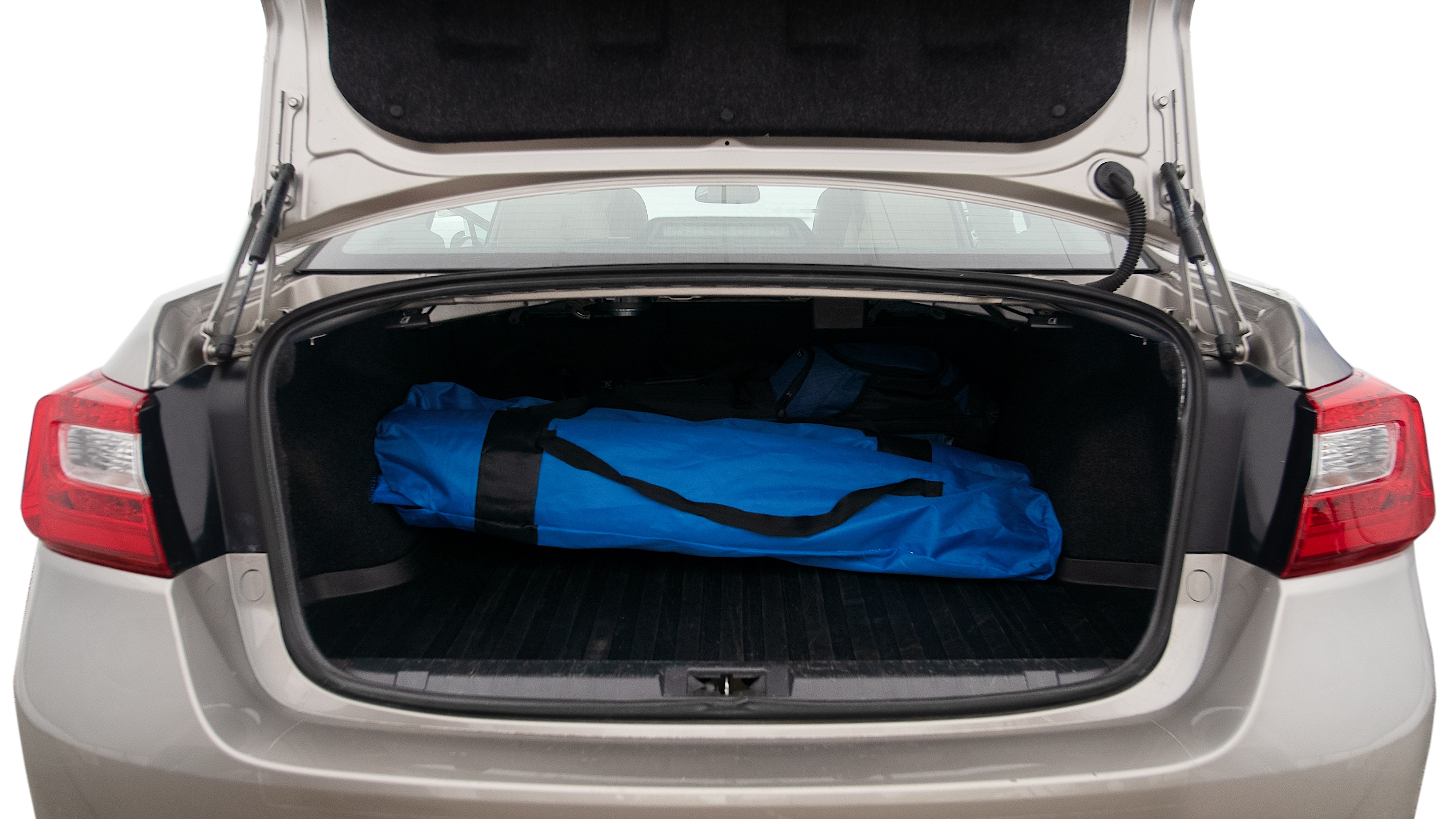 The trunk lid is open showing full view of the trunk. A baby stroller, three grocery carriers, two camping chairs in the carrying bag, and a set of golf clubs are placed inside.