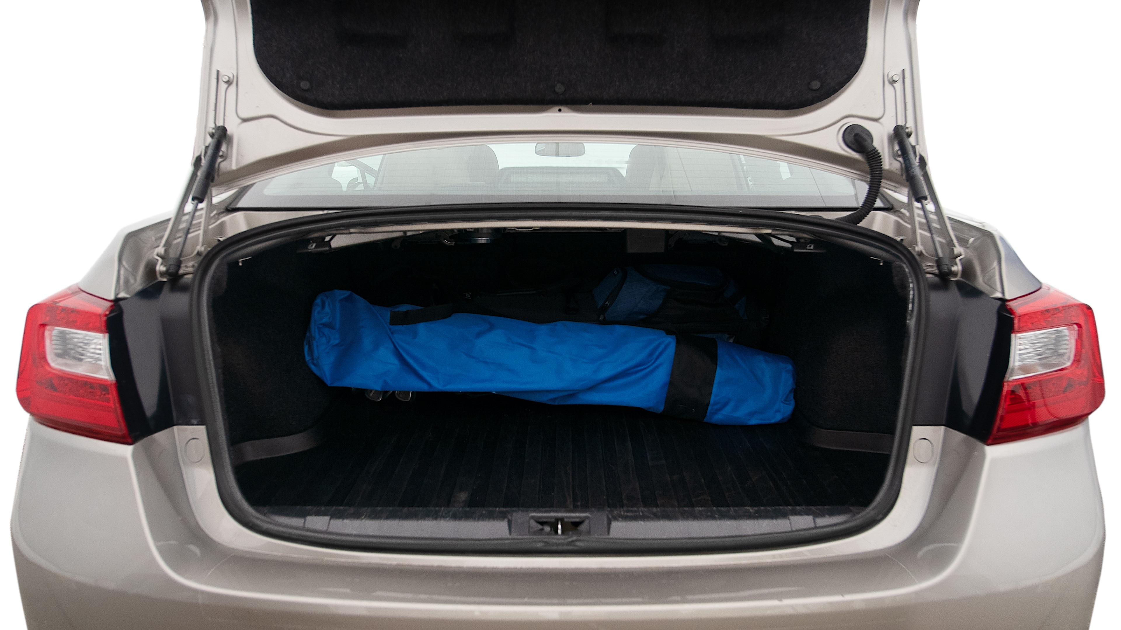 The trunk lid is open showing full view of the trunk. A baby stroller, three grocery carriers, two camping chairs in the carrying bag, and a set of golf clubs are placed inside.