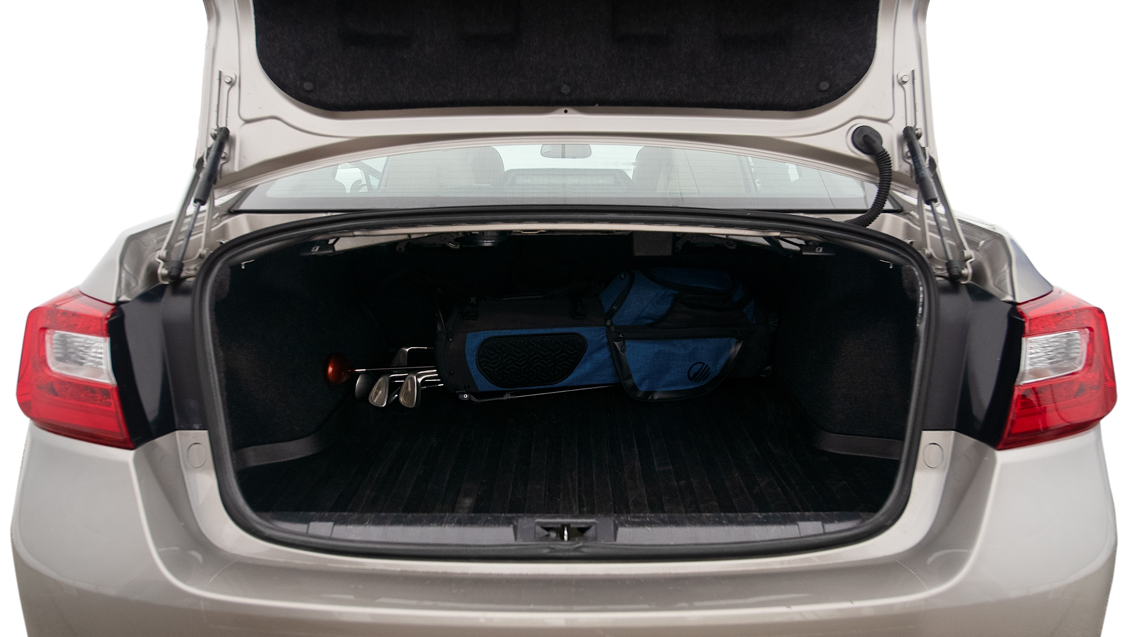 The trunk lid is open showing full view of the trunk. A baby stroller, three grocery carriers, two camping chairs in the carrying bag, and a set of golf clubs are placed inside.