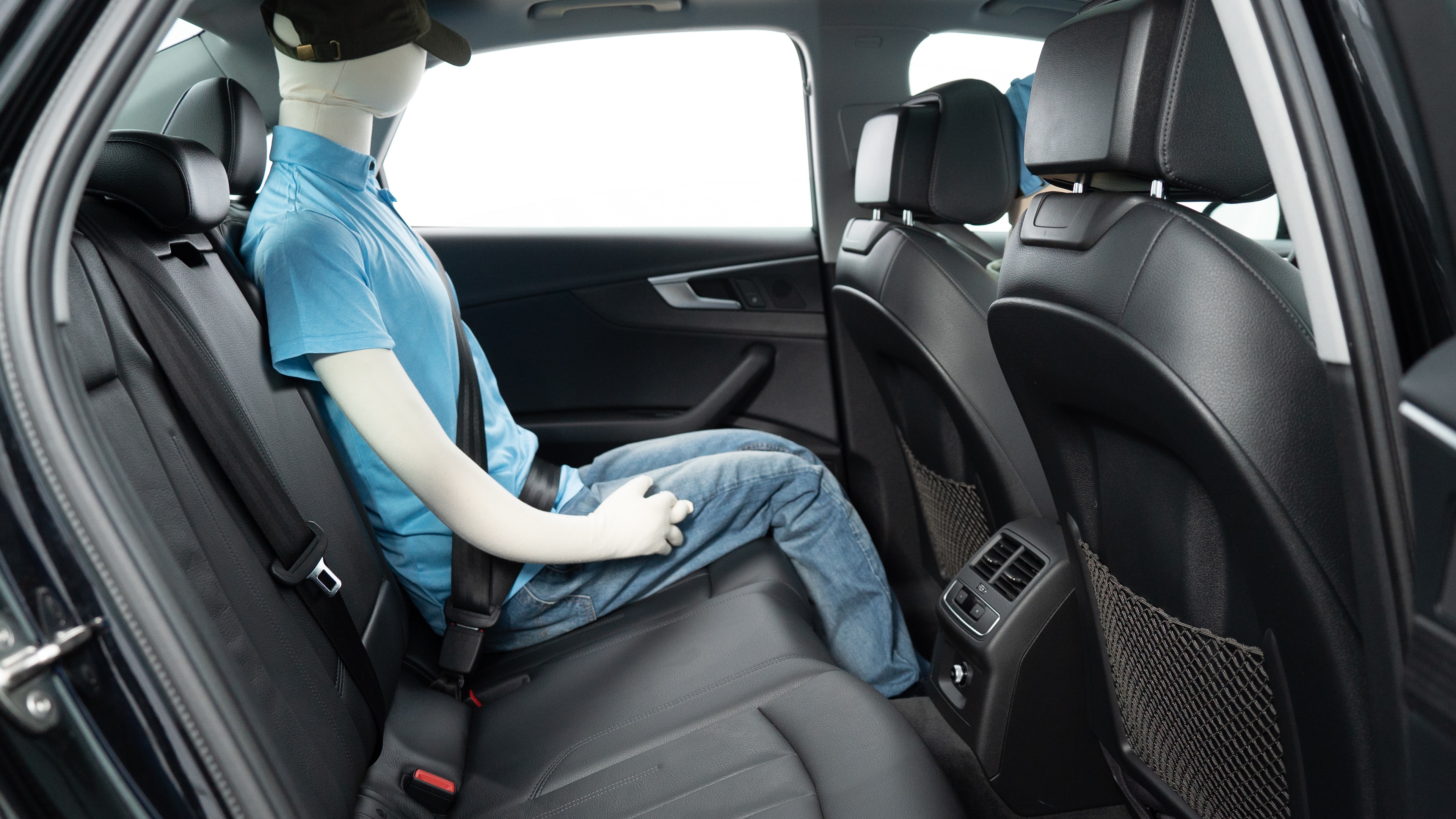 A series of second-row backseat photos is shown including one seating a baby seat, a dog and one seating a 6'1" mannequin.