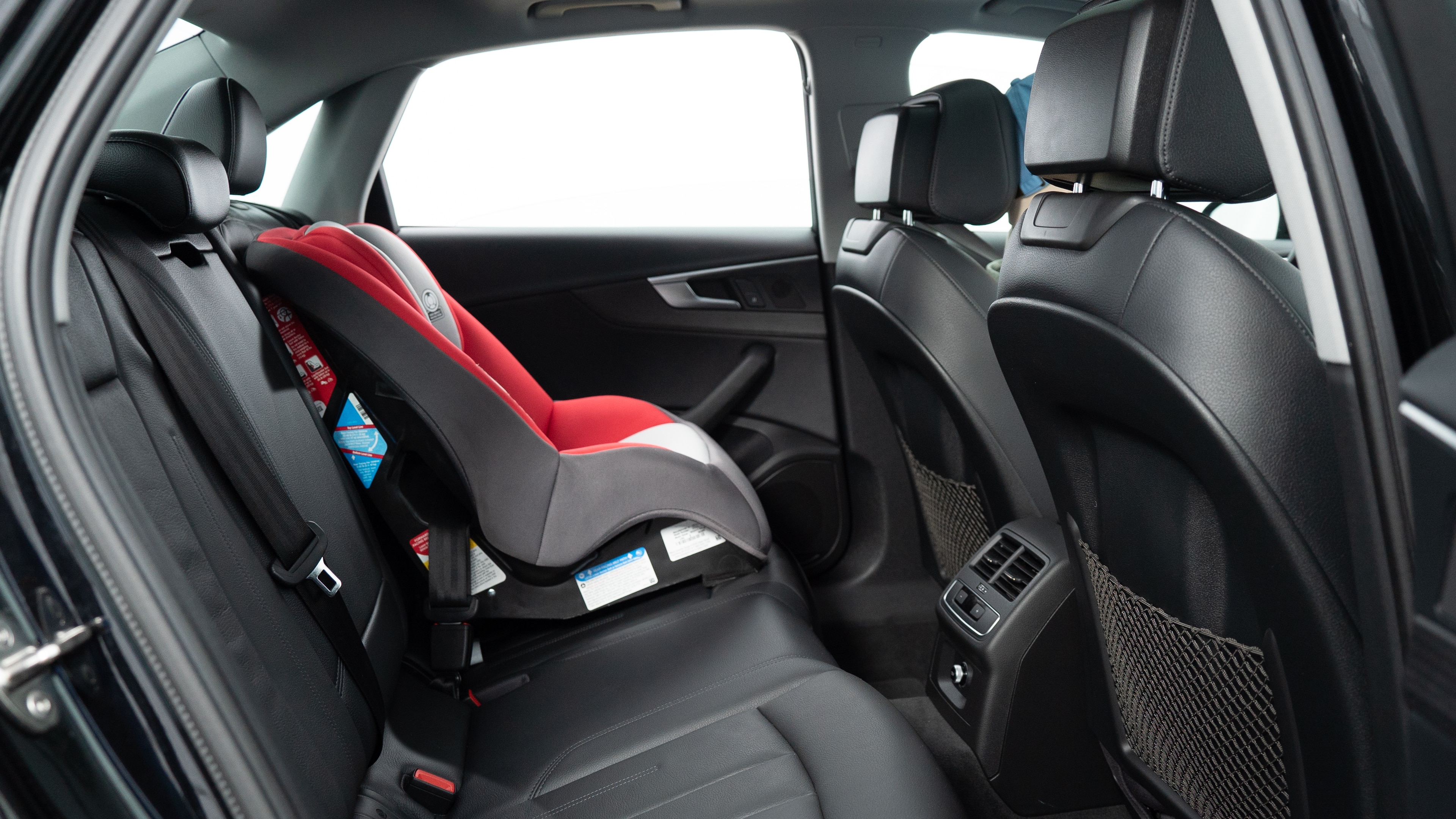 A series of second-row backseat photos is shown including one seating a baby seat, a dog and one seating a 6'1" mannequin.