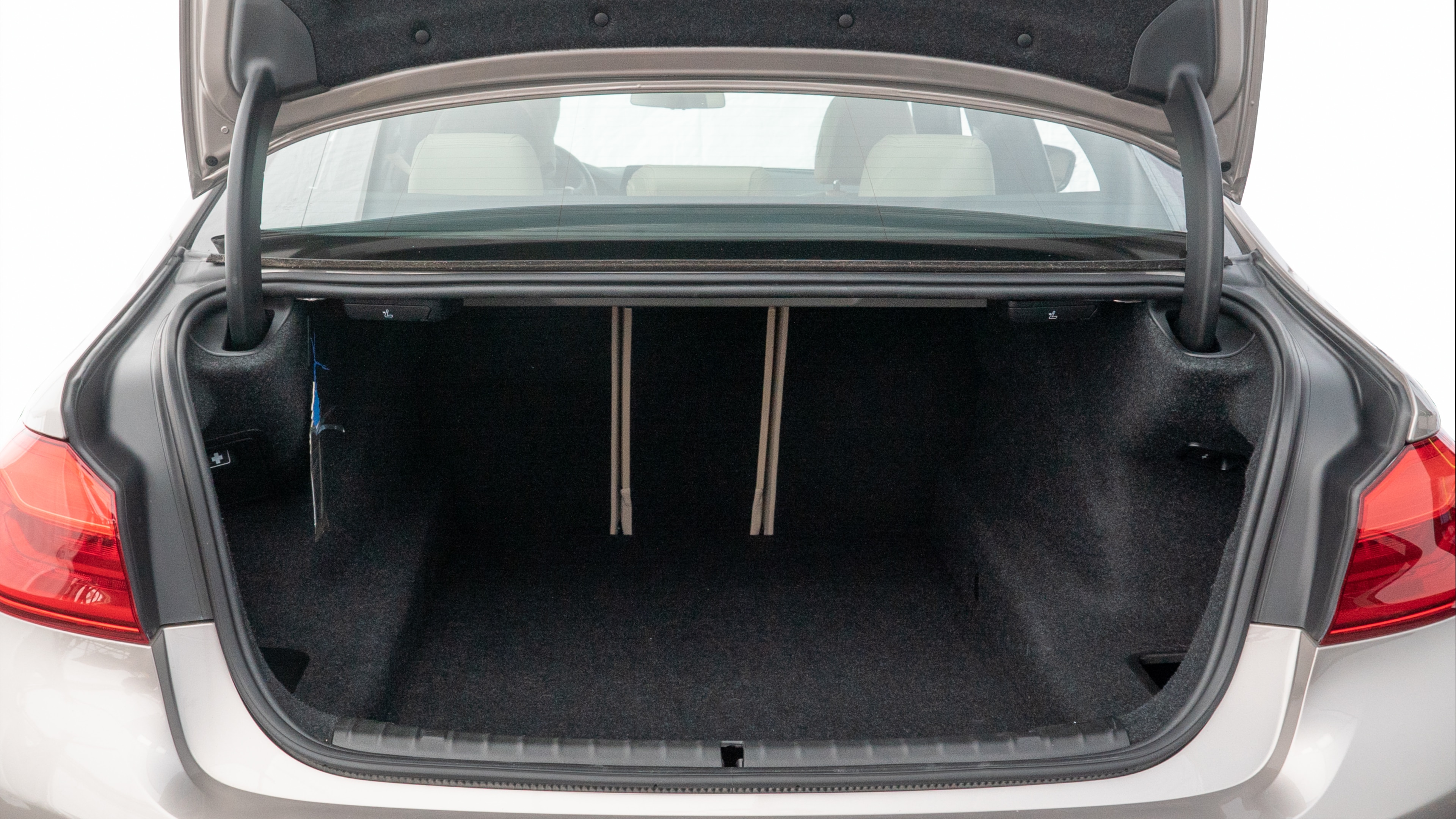 The trunk lid is open showing full view of the trunk. A baby stroller, three grocery carriers, two camping chairs in the carrying bag, and a set of golf clubs are placed inside.