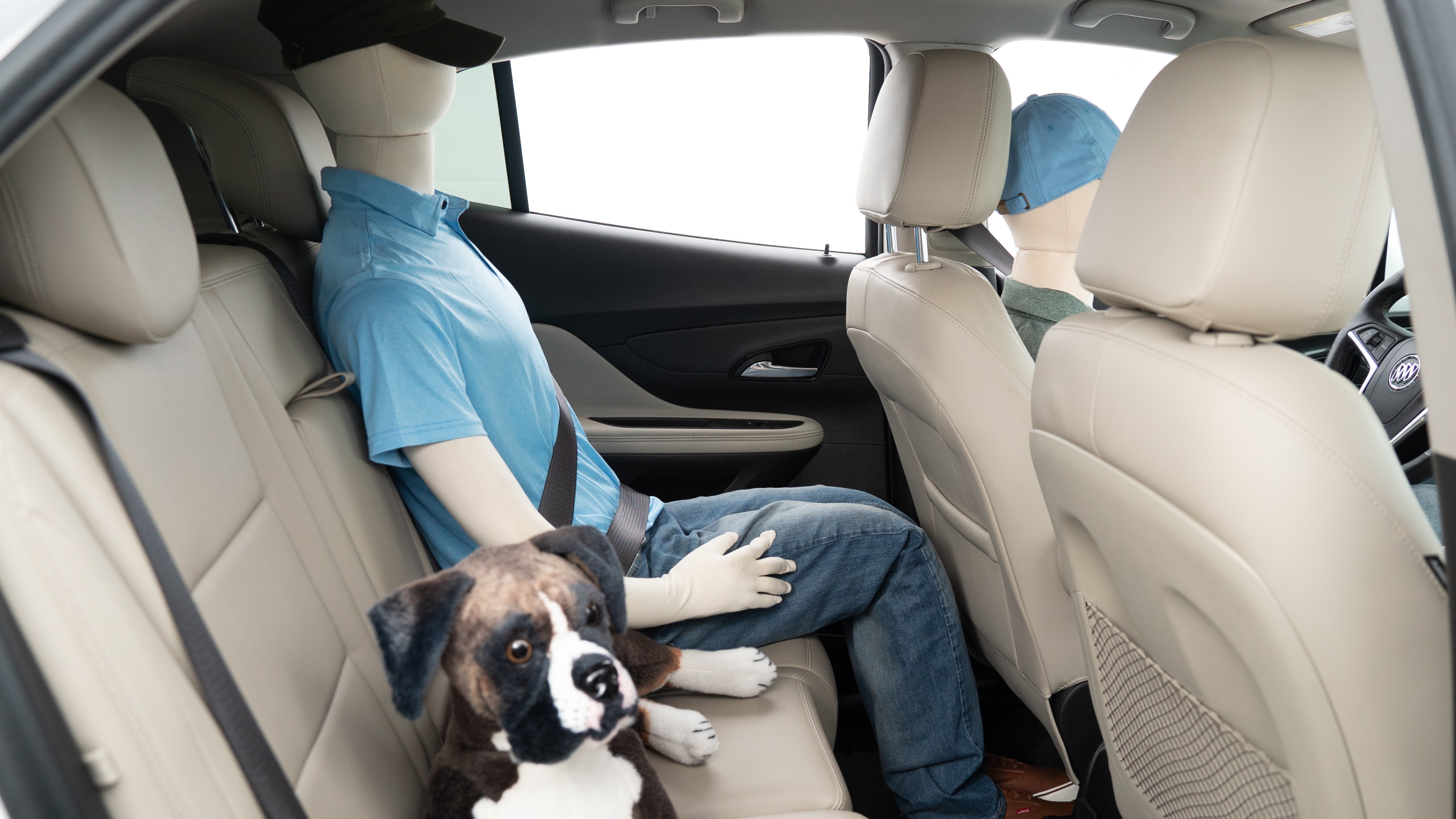 A series of second-row backseat photos is shown including one seating a baby seat, a dog and one seating a 6'1" mannequin.