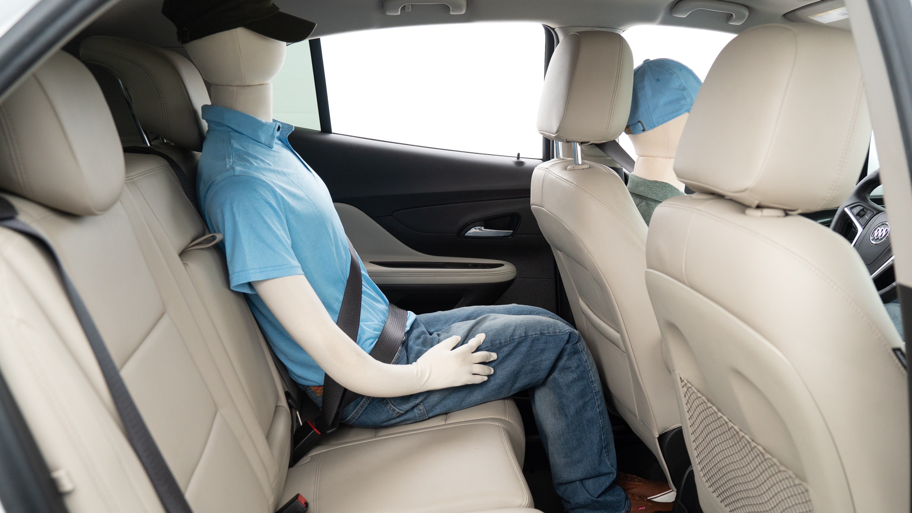 A series of second-row backseat photos is shown including one seating a baby seat, a dog and one seating a 6'1" mannequin.