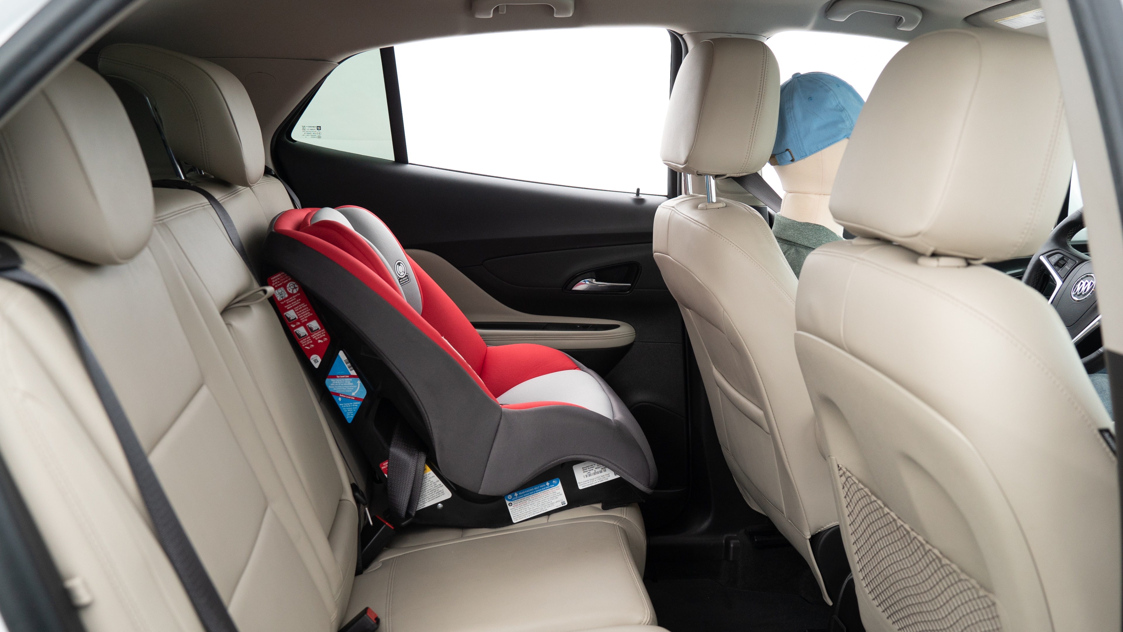 A series of second-row backseat photos is shown including one seating a baby seat, a dog and one seating a 6'1" mannequin.